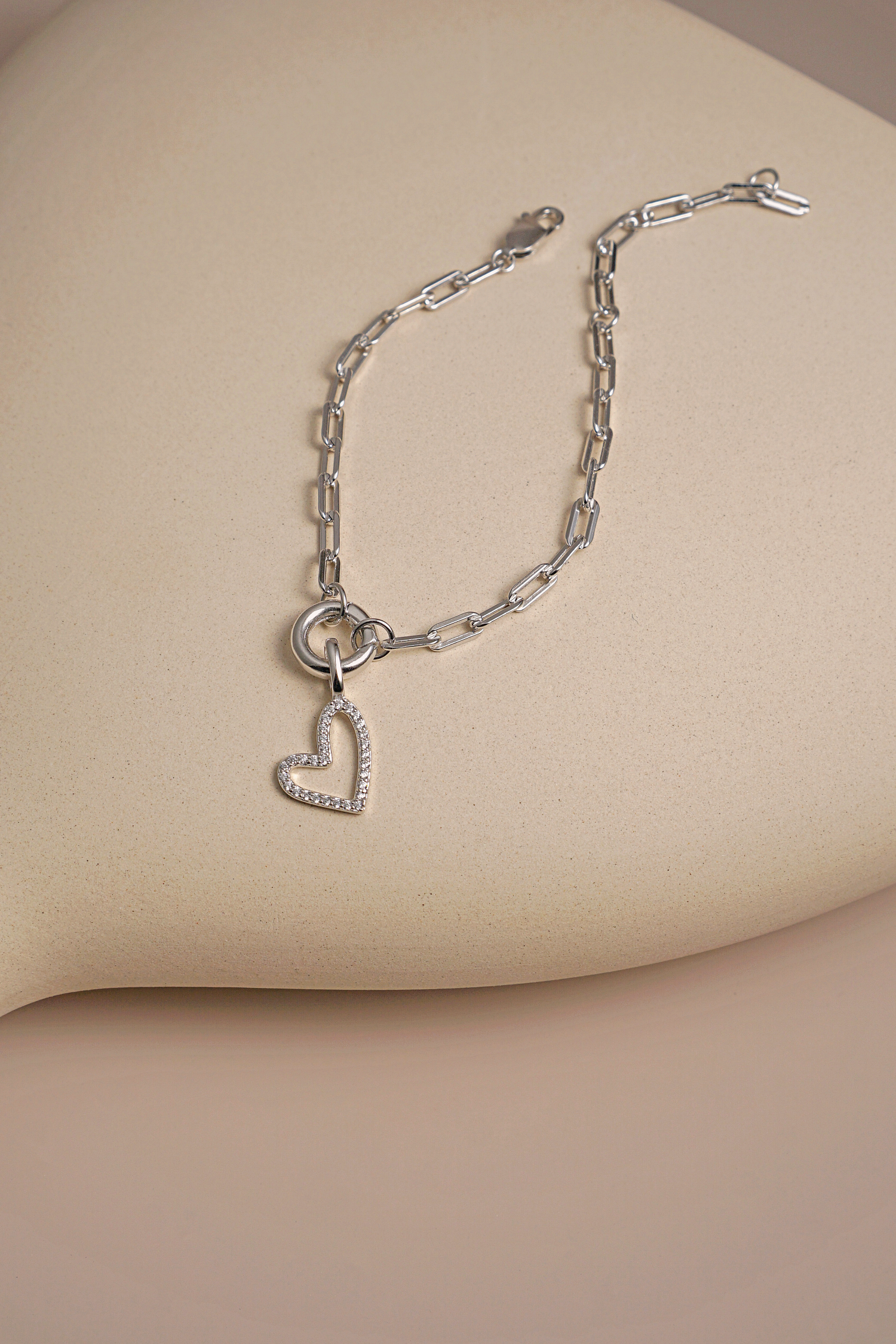 A stylish silver charm carrier bracelet chain featuring a sleek design and a charm holder mechanism, perfect for personalizing with various charms.