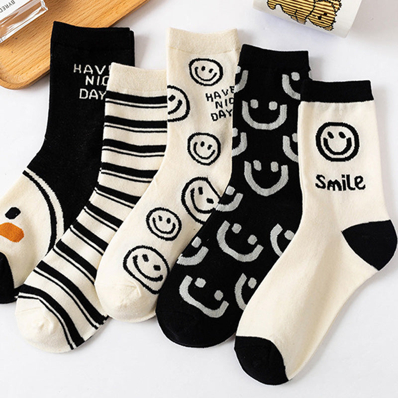 A pair of women's socks featuring a cheerful cartoon smiling face design, made from soft cotton material.