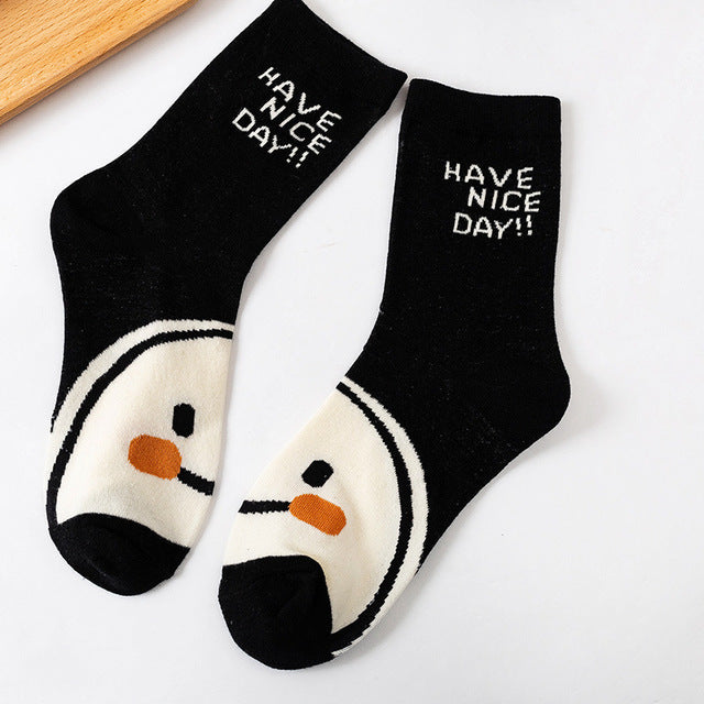 A pair of women's socks featuring a cheerful cartoon smiling face design, made from soft cotton material.