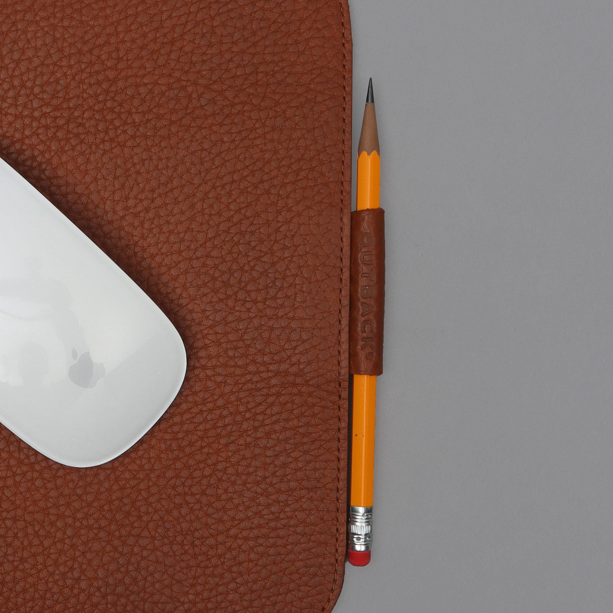 Mouse on leather mousepad with pencil