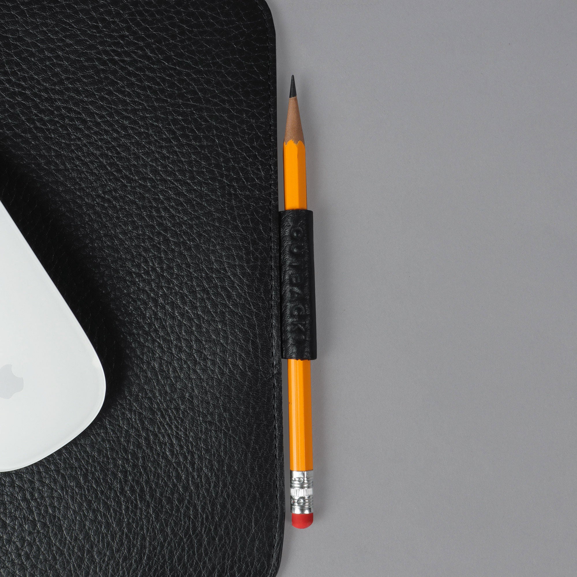 A square mouse pad made from premium full grain leather, featuring a smooth surface and space for a pen or Apple Pencil.