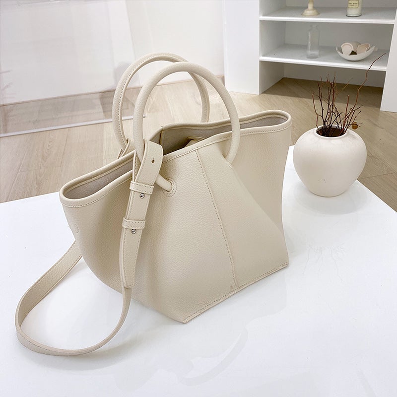 A stylish black and milky white soft waxy tote bag for women, showcasing its trendy street fashion design and spacious interior.