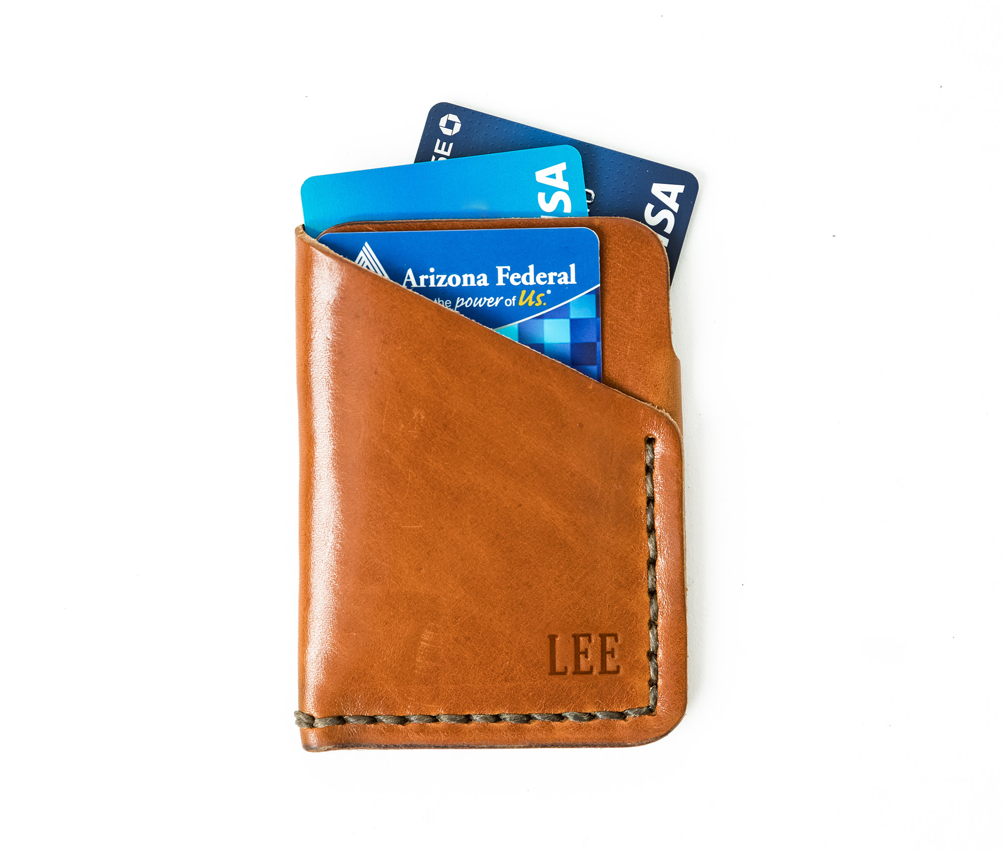 Tall Minimalist Wallet made of genuine full grain leather, featuring two card slots and a center cash slot, displayed with a muslin bag.