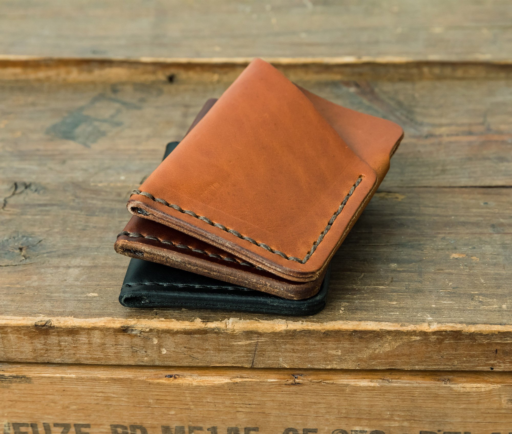 Tall Minimalist Wallet made of genuine full grain leather, featuring two card slots and a center cash slot, displayed with a muslin bag.