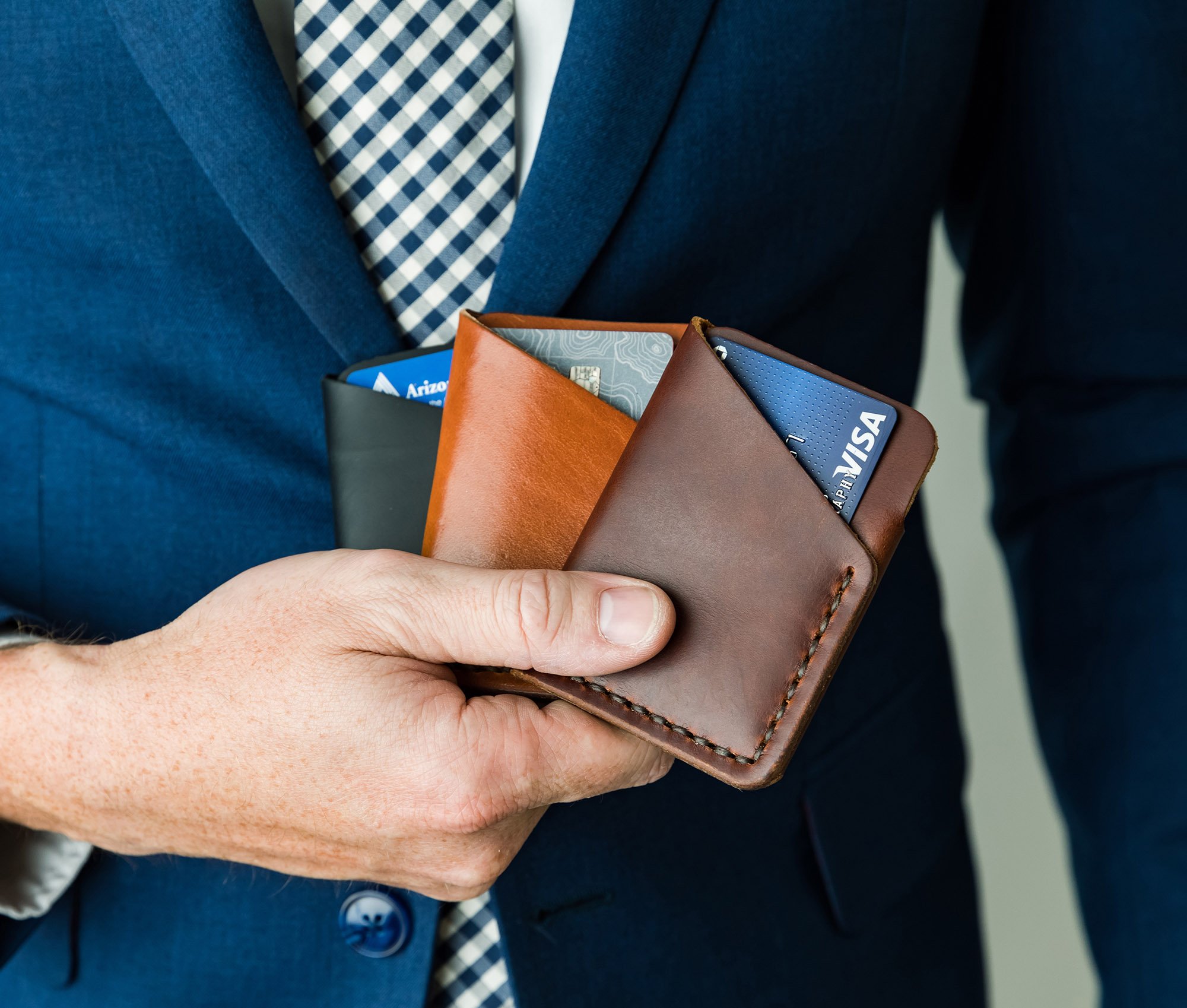 Tall Minimalist Wallet made of genuine full grain leather, featuring two card slots and a center cash slot, displayed with a muslin bag.