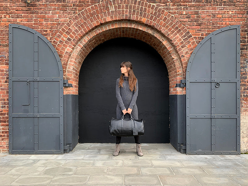 The Endre Weekender vintage leather duffle bag in black, showcasing its smooth texture and stylish design with leather handles and shoulder strap.