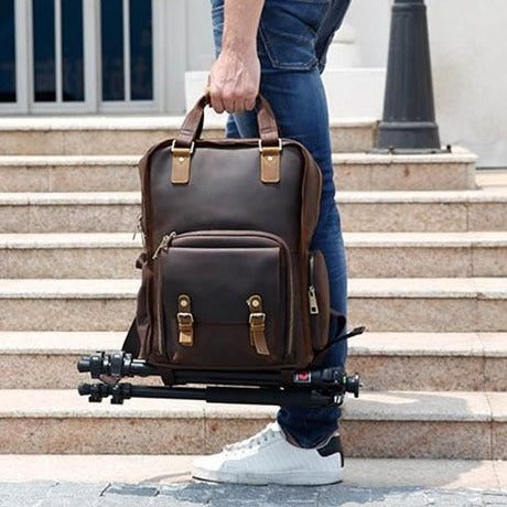 The Gaetano Large Leather Backpack Camera Bag showcasing its full grain leather design, quick access pocket, and tripod holder.