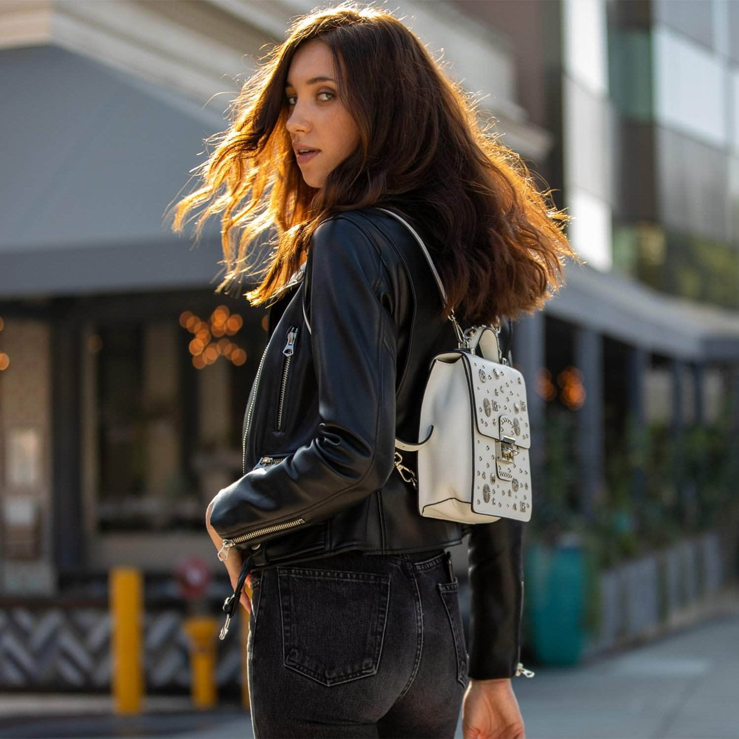 SUSU Hollywood Backpack Leather Purse in white with silver appliqués, showcasing its structured design and adjustable straps.