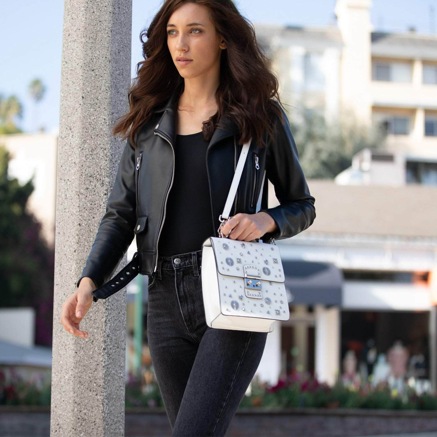 SUSU Hollywood Backpack Leather Purse in white with silver appliqués, showcasing its structured design and adjustable straps.