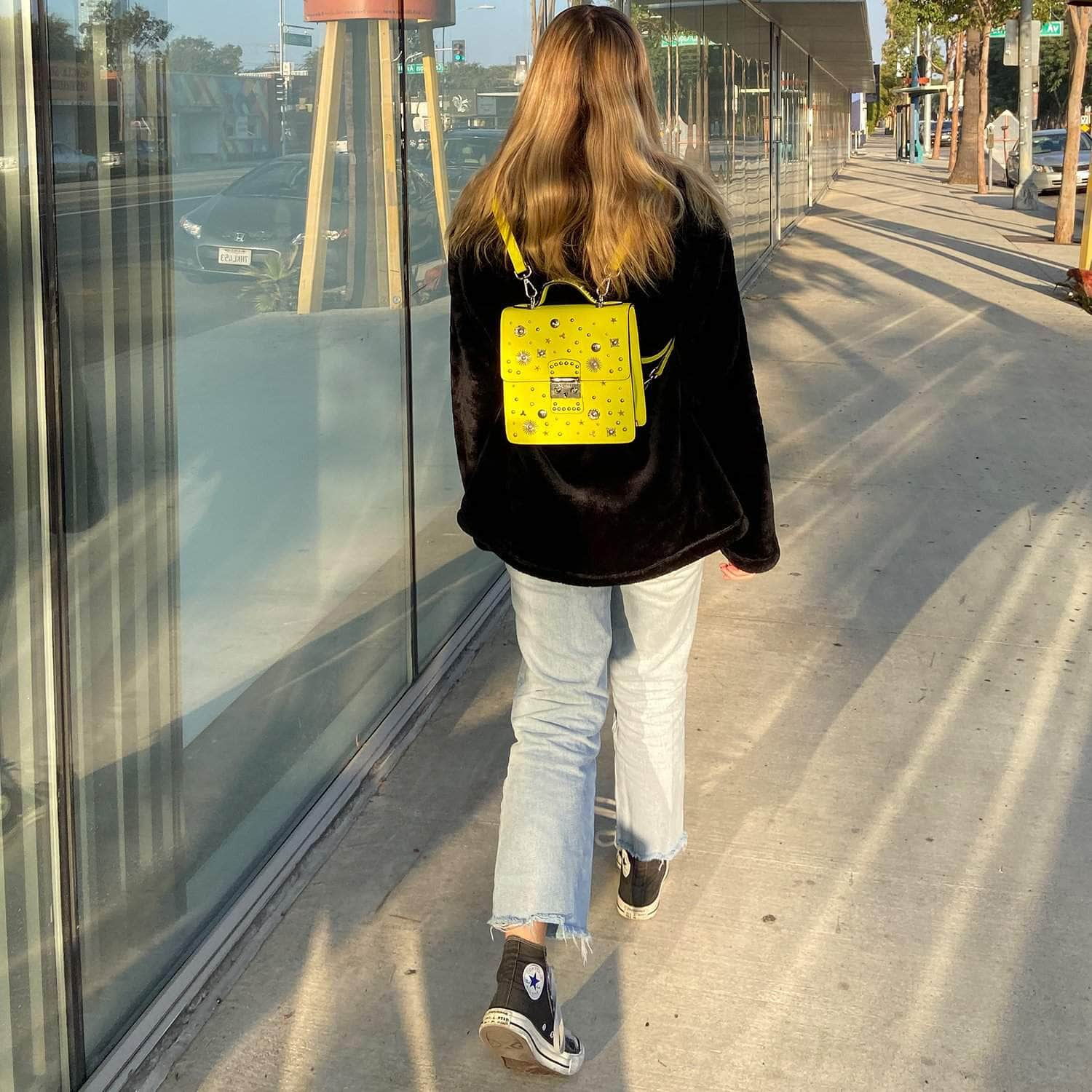 SUSU Hollywood Backpack Purse in vibrant yellow leather with silver hardware, showcasing its structured design and adjustable straps.