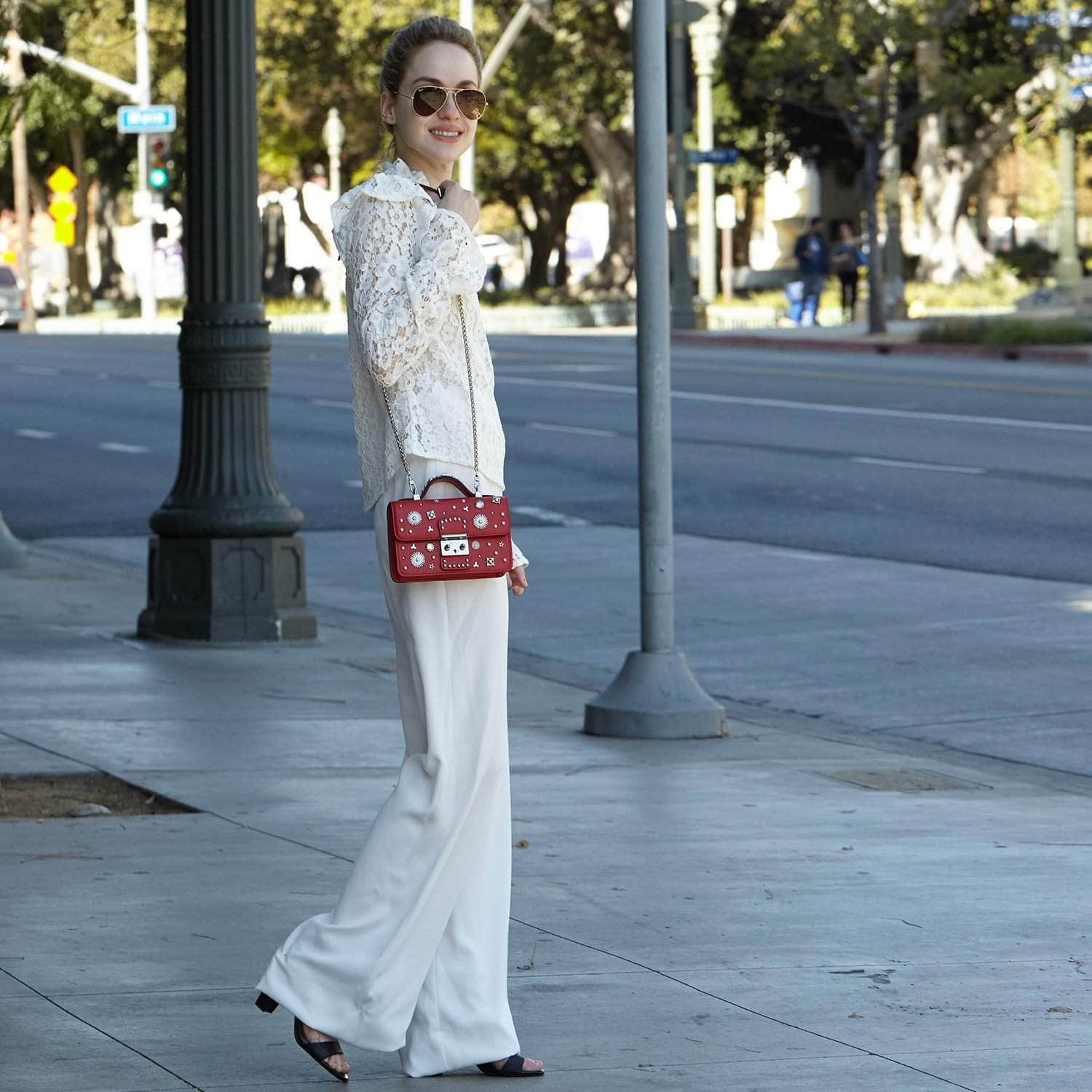 The Hollywood Studded Leather Crossbody Bag in red with silver studs and chain strap, showcasing its stylish design and functionality.