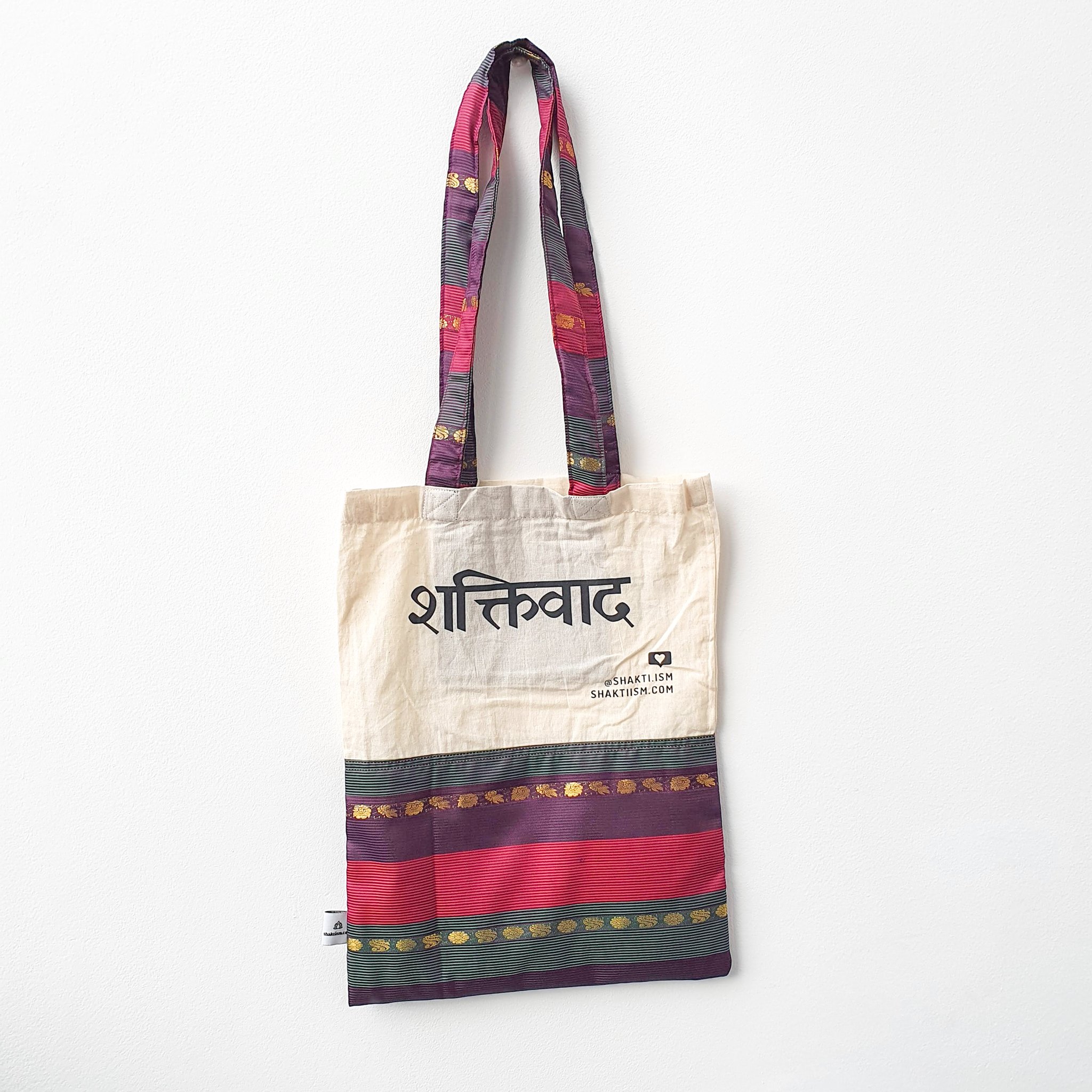 A vibrant Independence sari tote bag handcrafted from repurposed sari fabric, showcasing unique patterns and colors, with a message promoting women's economic independence.