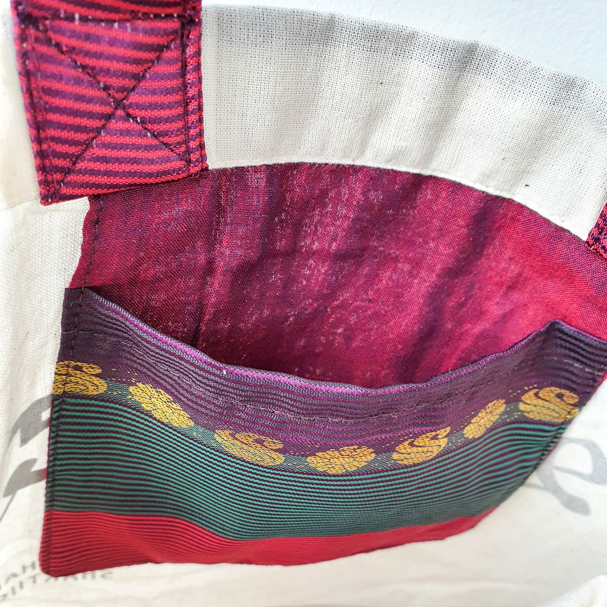 A vibrant Independence sari tote bag handcrafted from repurposed sari fabric, showcasing unique patterns and colors, with a message promoting women's economic independence.