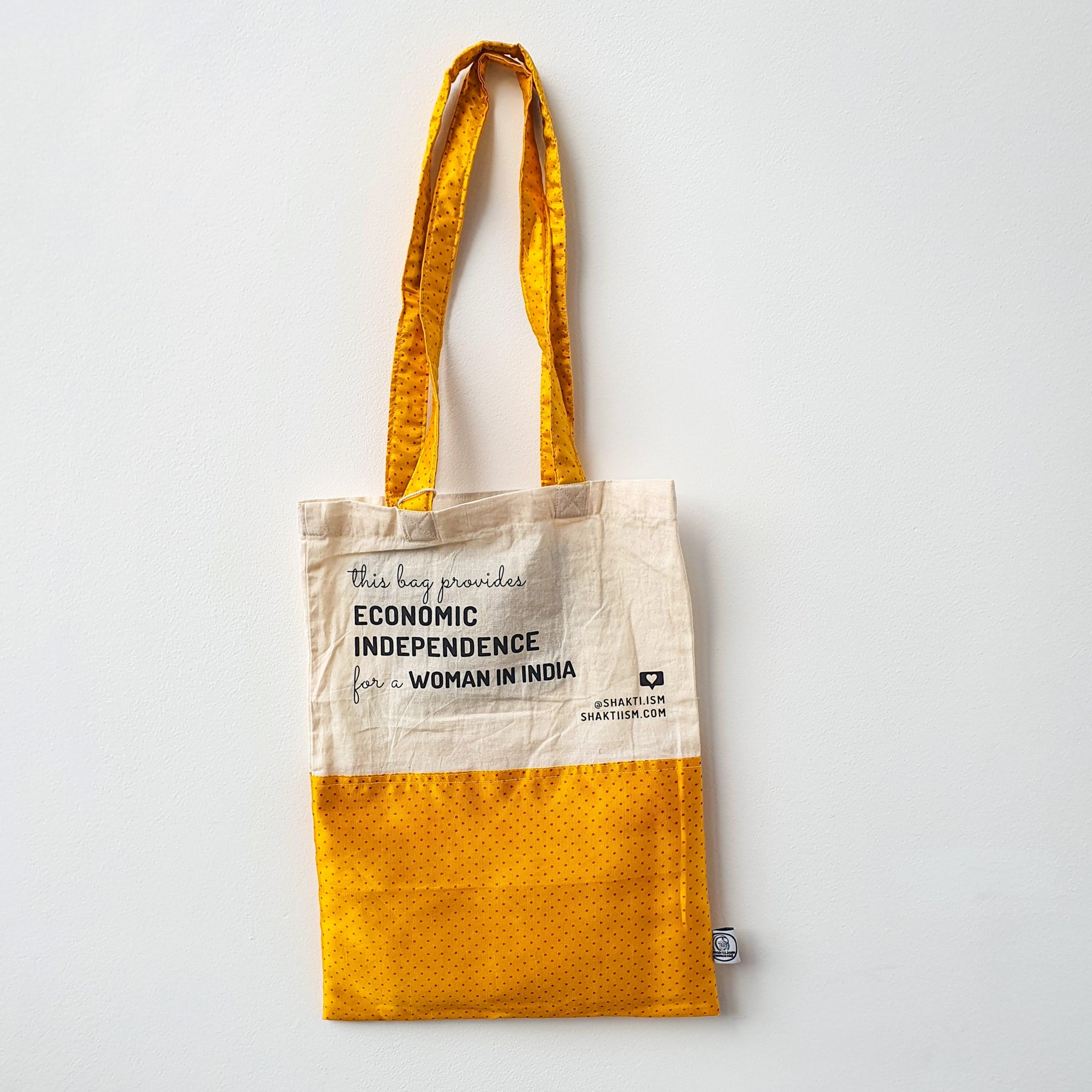 A vibrant Independence sari tote bag handcrafted from repurposed sari fabric, showcasing unique patterns and colors, with a message promoting women's economic independence.