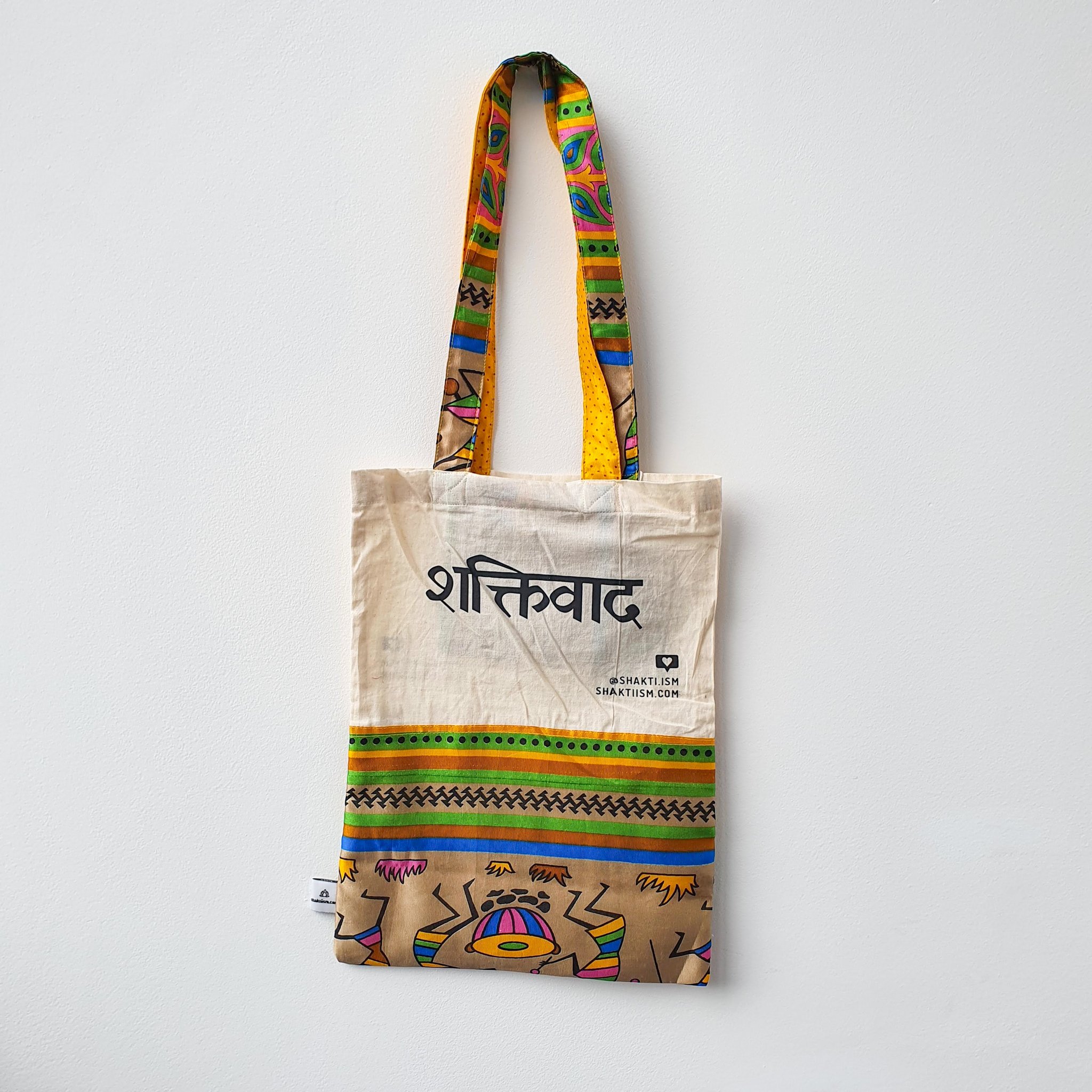 A vibrant Independence sari tote bag handcrafted from repurposed sari fabric, showcasing unique patterns and colors, with a message promoting women's economic independence.