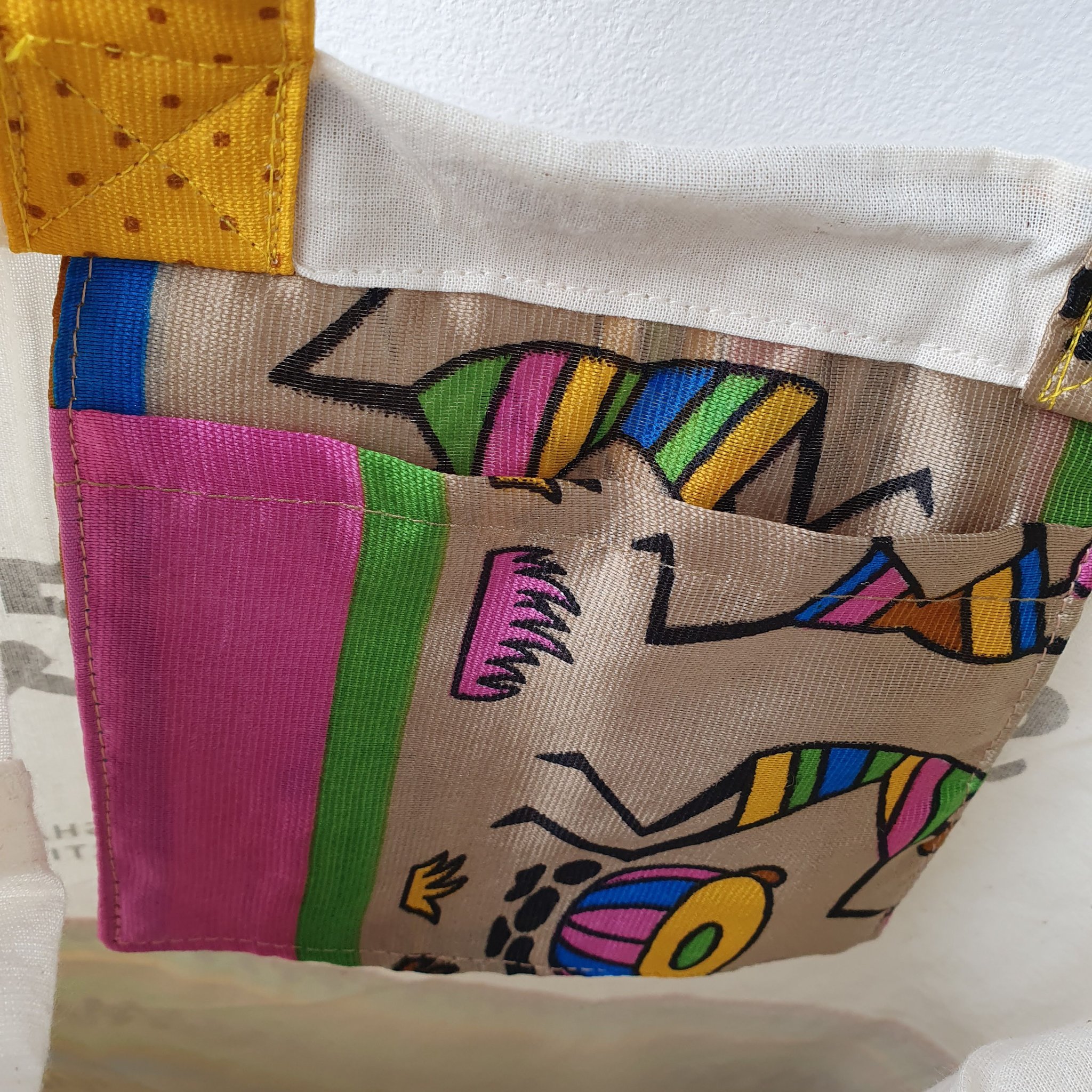 A vibrant Independence sari tote bag handcrafted from repurposed sari fabric, showcasing unique patterns and colors, with a message promoting women's economic independence.