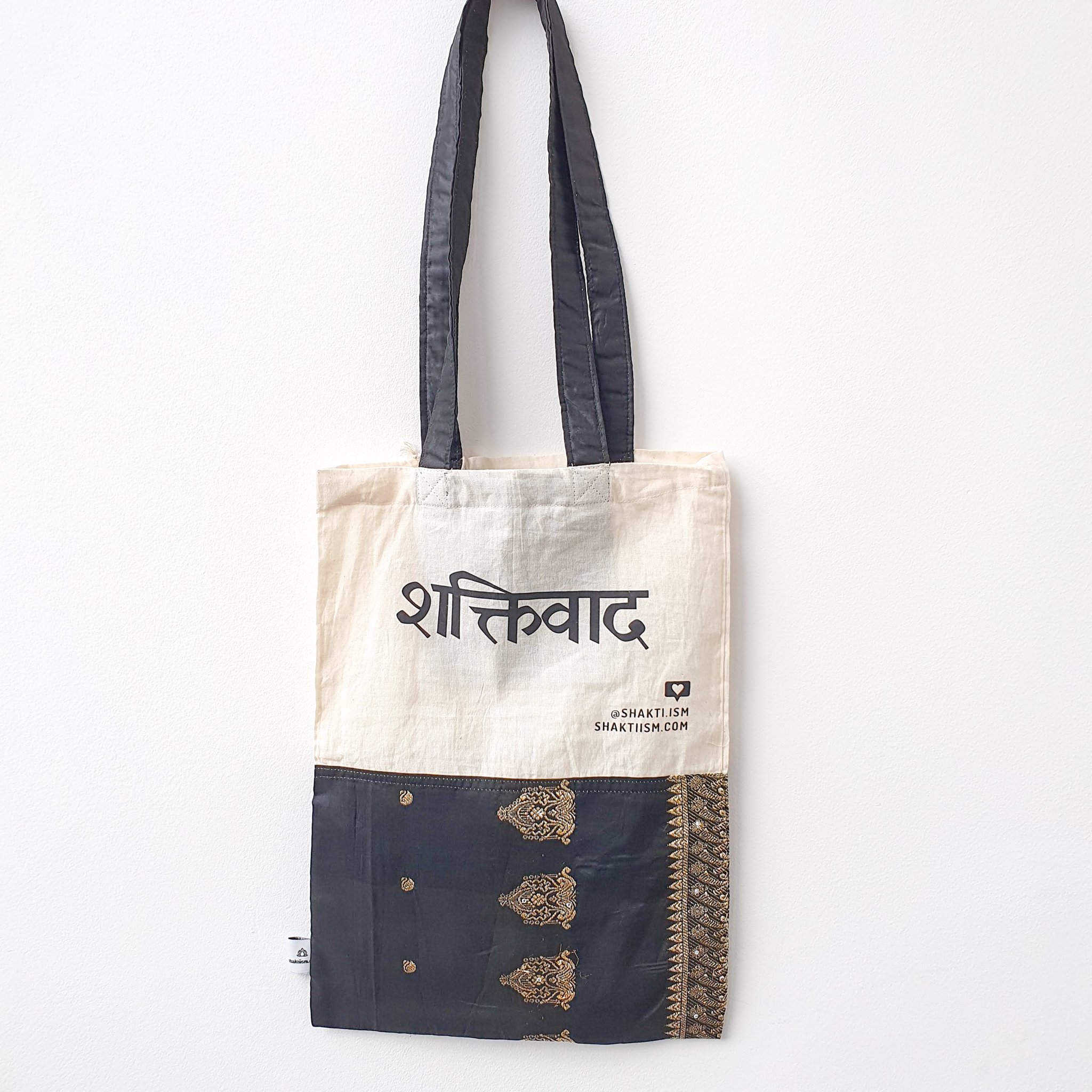 A vibrant Independence sari tote bag handcrafted from repurposed sari fabric, showcasing unique patterns and colors, with a message promoting women's economic independence.