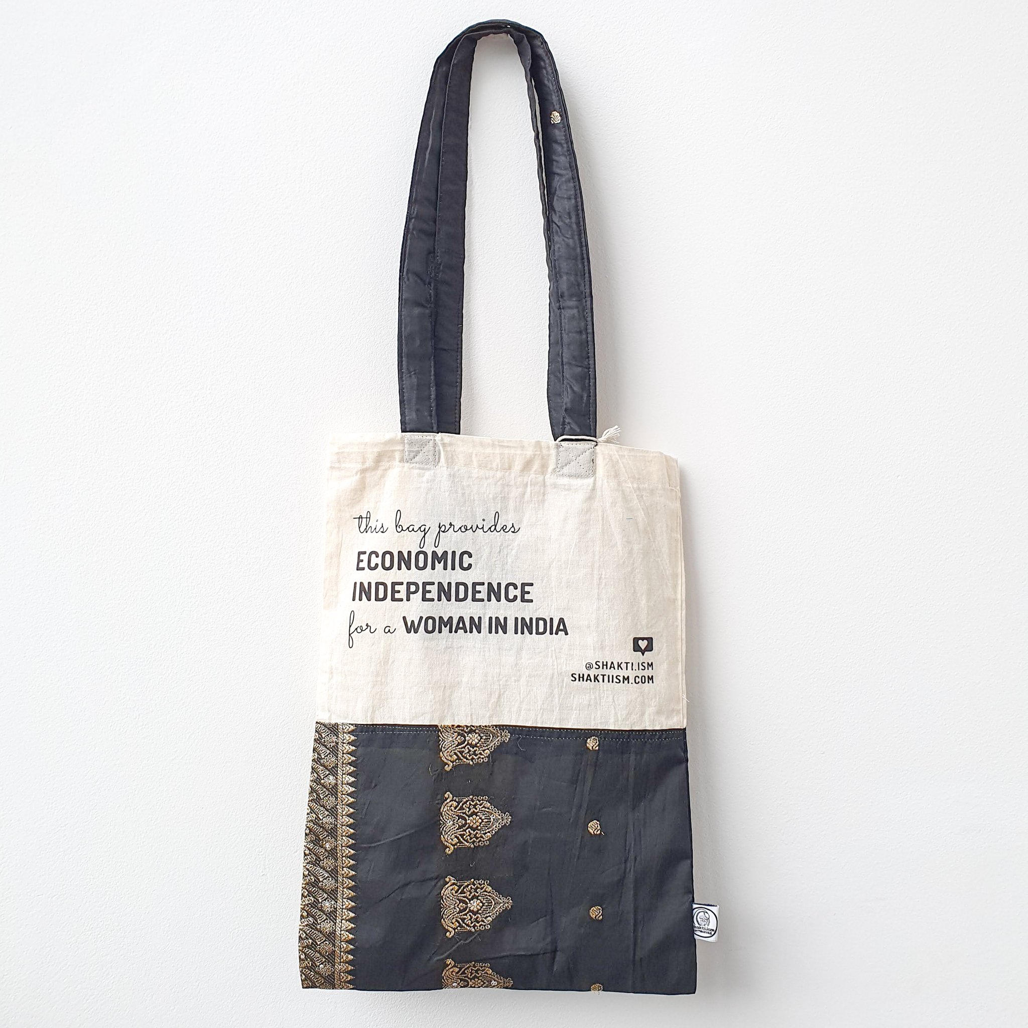 A vibrant Independence sari tote bag handcrafted from repurposed sari fabric, showcasing unique patterns and colors, with a message promoting women's economic independence.