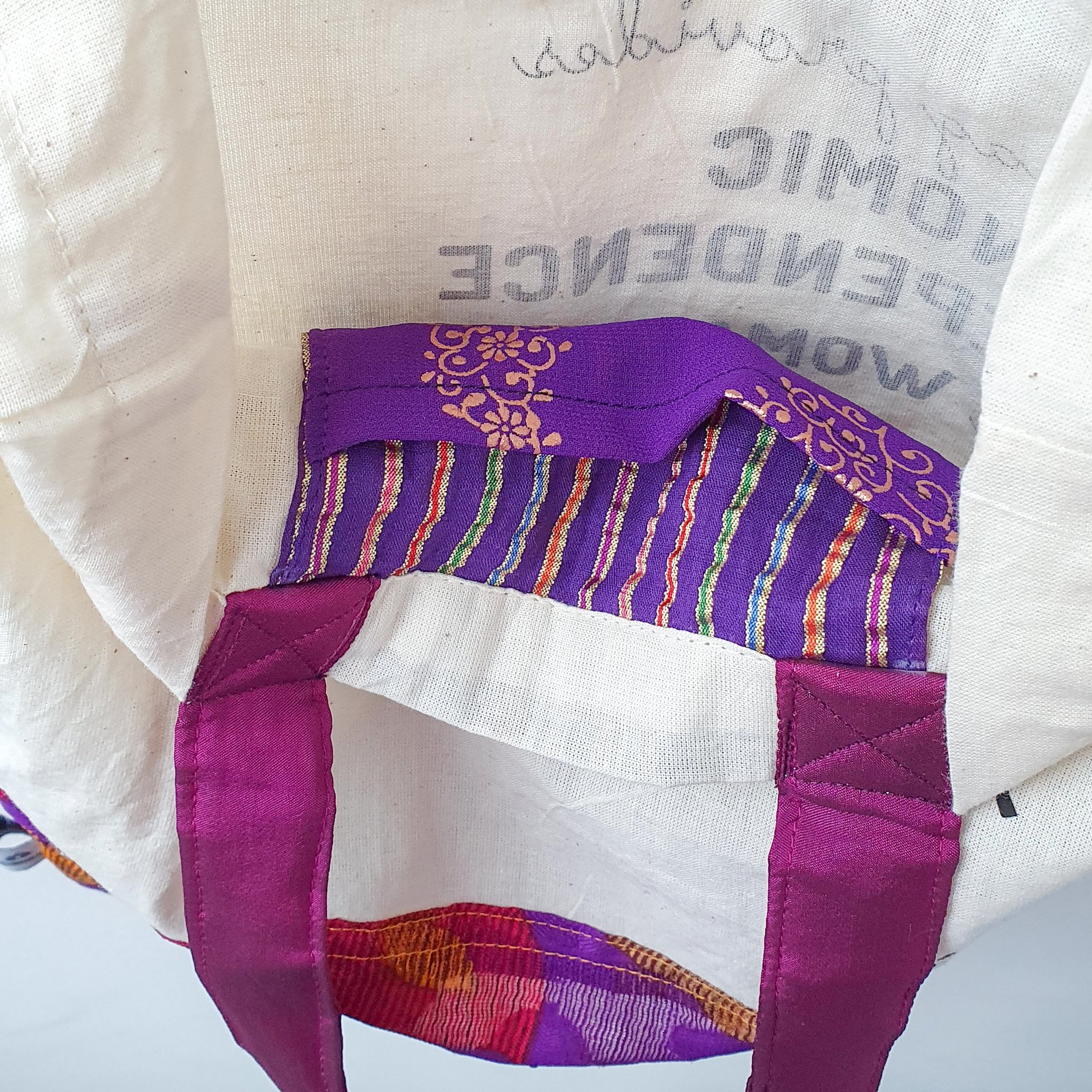 A vibrant Independence sari tote bag handcrafted from repurposed sari fabric, showcasing unique patterns and colors, with a message promoting women's economic independence.