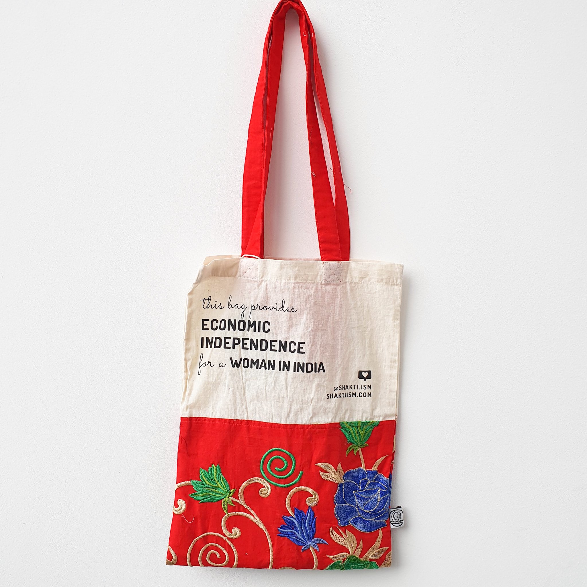 A vibrant Independence sari tote bag handcrafted from repurposed sari fabric, showcasing unique patterns and colors, with a message promoting women's economic independence.