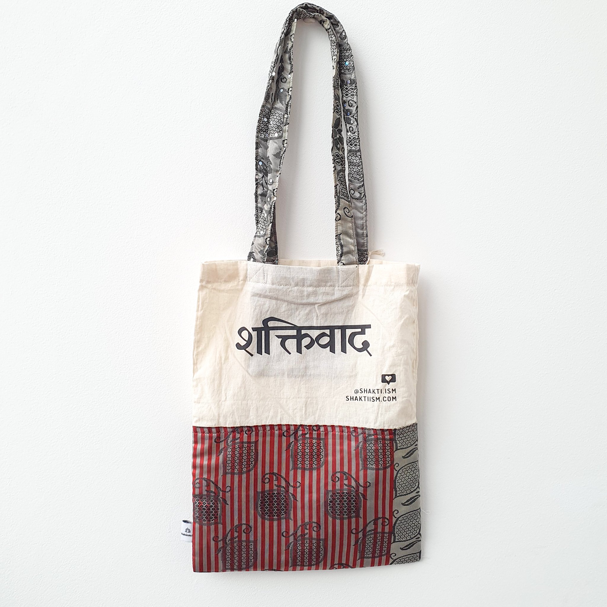 A vibrant Independence sari tote bag handcrafted from repurposed sari fabric, showcasing unique patterns and colors, with a message promoting women's economic independence.