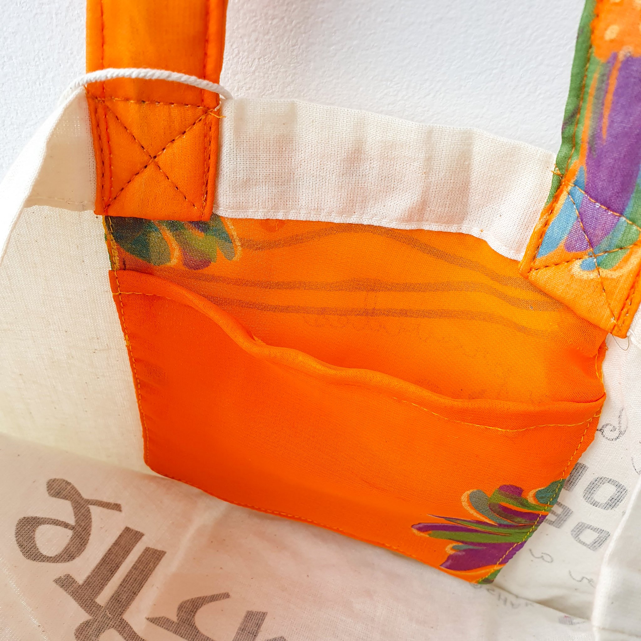 A vibrant Independence sari tote bag handcrafted from repurposed sari fabric, showcasing unique patterns and colors, with a message promoting women's economic independence.