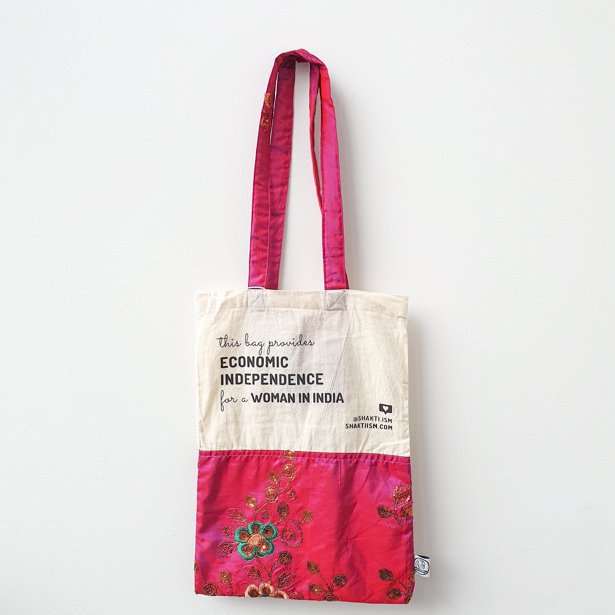 A vibrant Independence sari tote bag handcrafted from repurposed sari fabric, showcasing unique patterns and colors, with a message promoting women's economic independence.