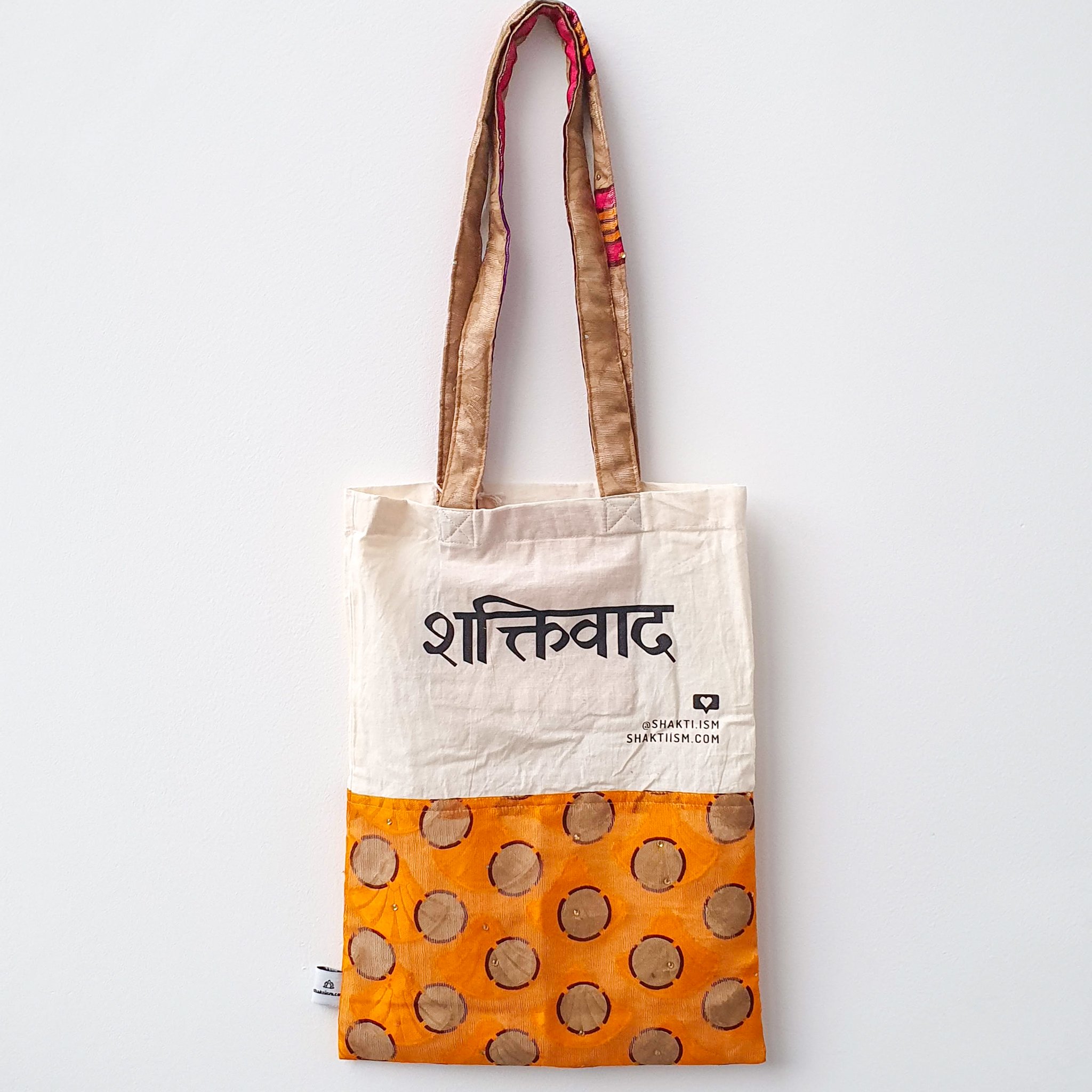 A vibrant Independence sari tote bag handcrafted from repurposed sari fabric, showcasing unique patterns and colors, with a message promoting women's economic independence.