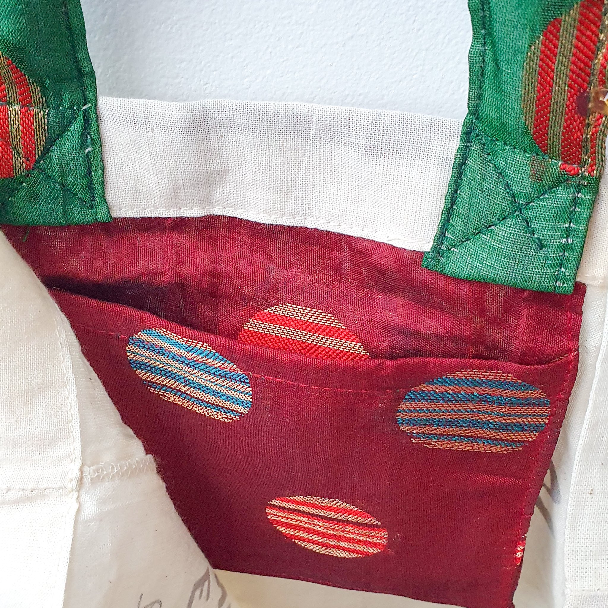 A vibrant Independence sari tote bag handcrafted from repurposed sari fabric, showcasing unique patterns and colors, with a message promoting women's economic independence.