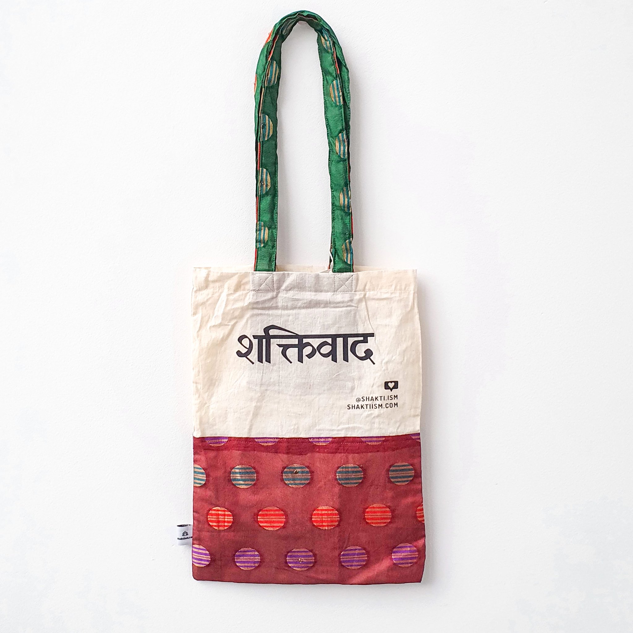 A vibrant Independence sari tote bag handcrafted from repurposed sari fabric, showcasing unique patterns and colors, with a message promoting women's economic independence.