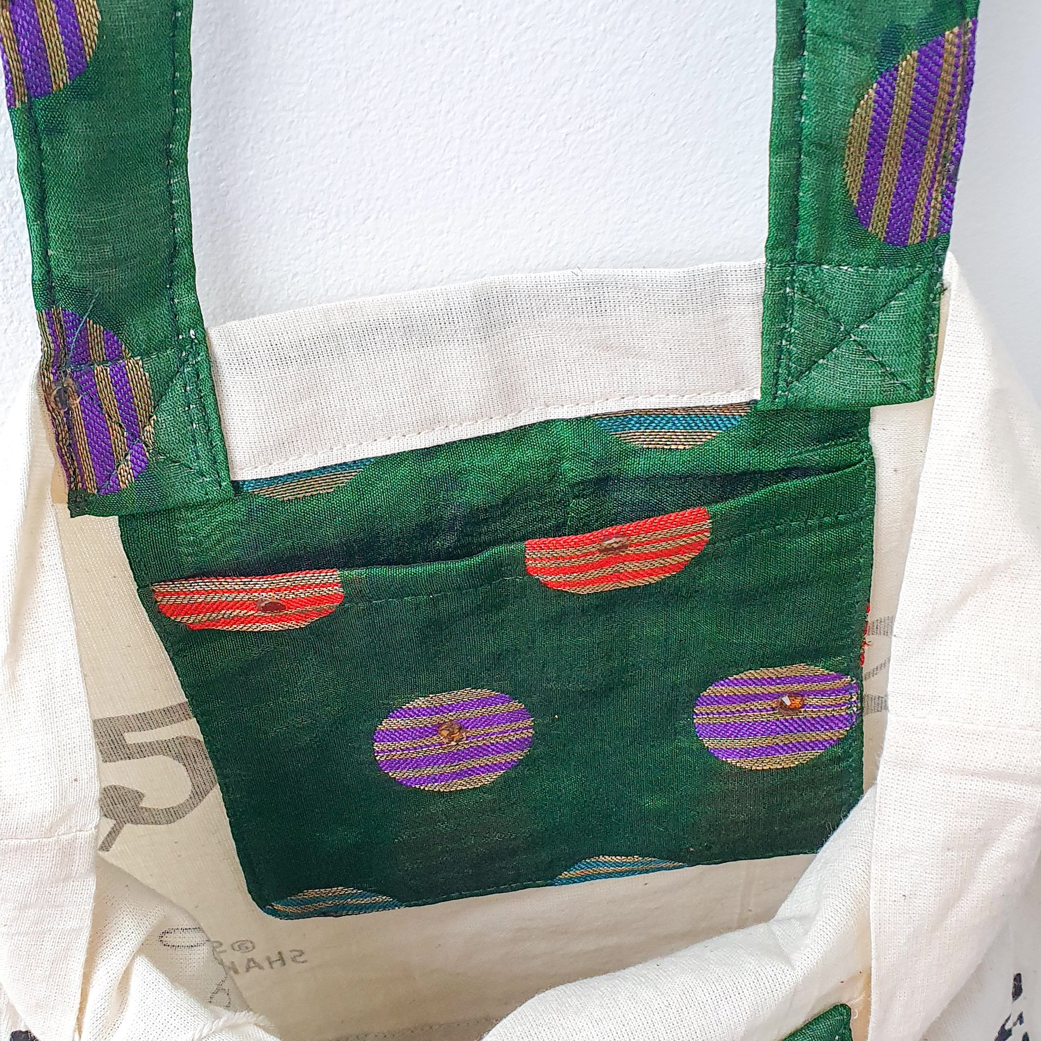 A vibrant Independence sari tote bag handcrafted from repurposed sari fabric, showcasing unique patterns and colors, with a message promoting women's economic independence.