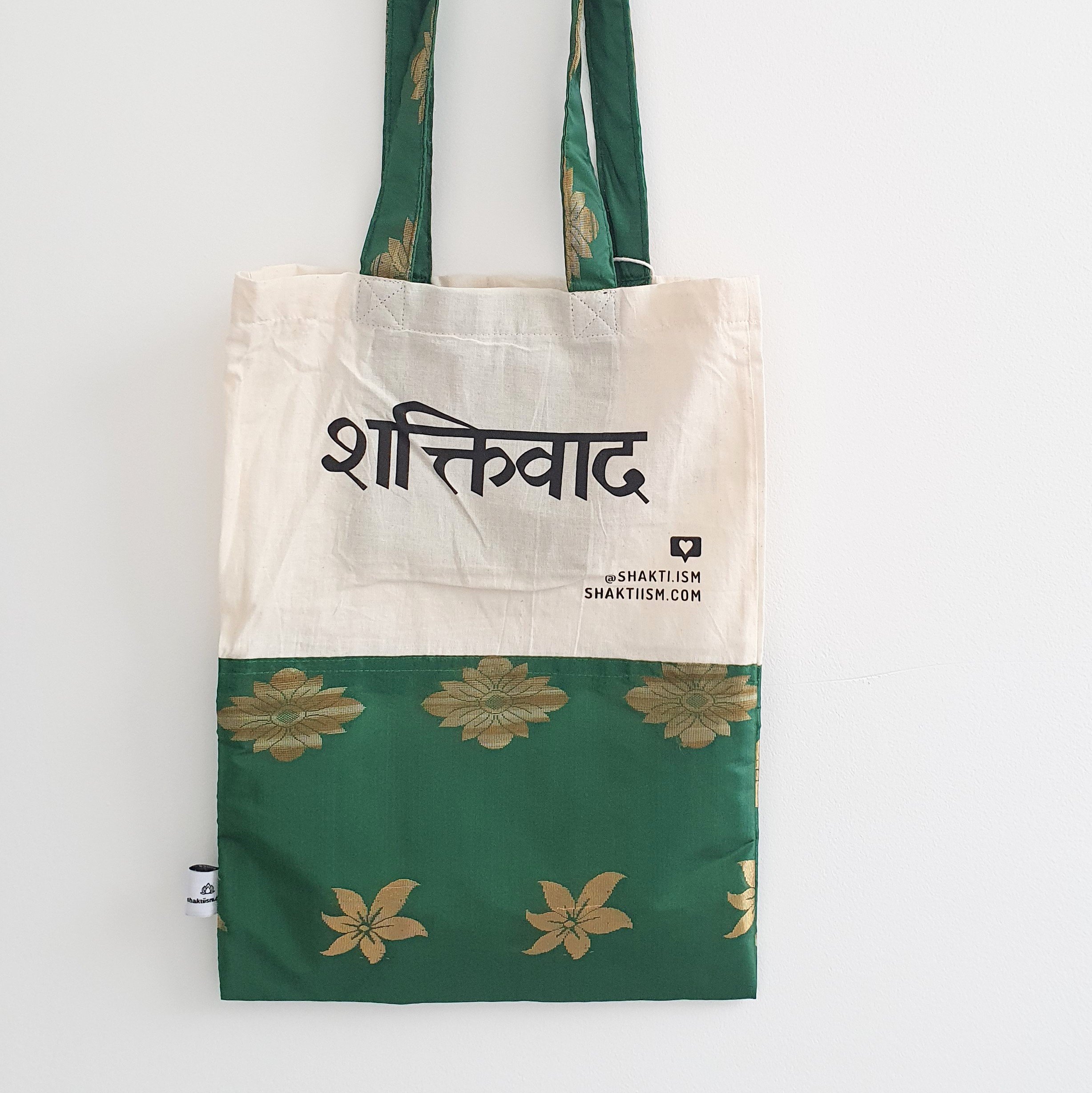 A vibrant Independence sari tote bag handcrafted from repurposed sari fabric, showcasing unique patterns and colors, with a message promoting women's economic independence.