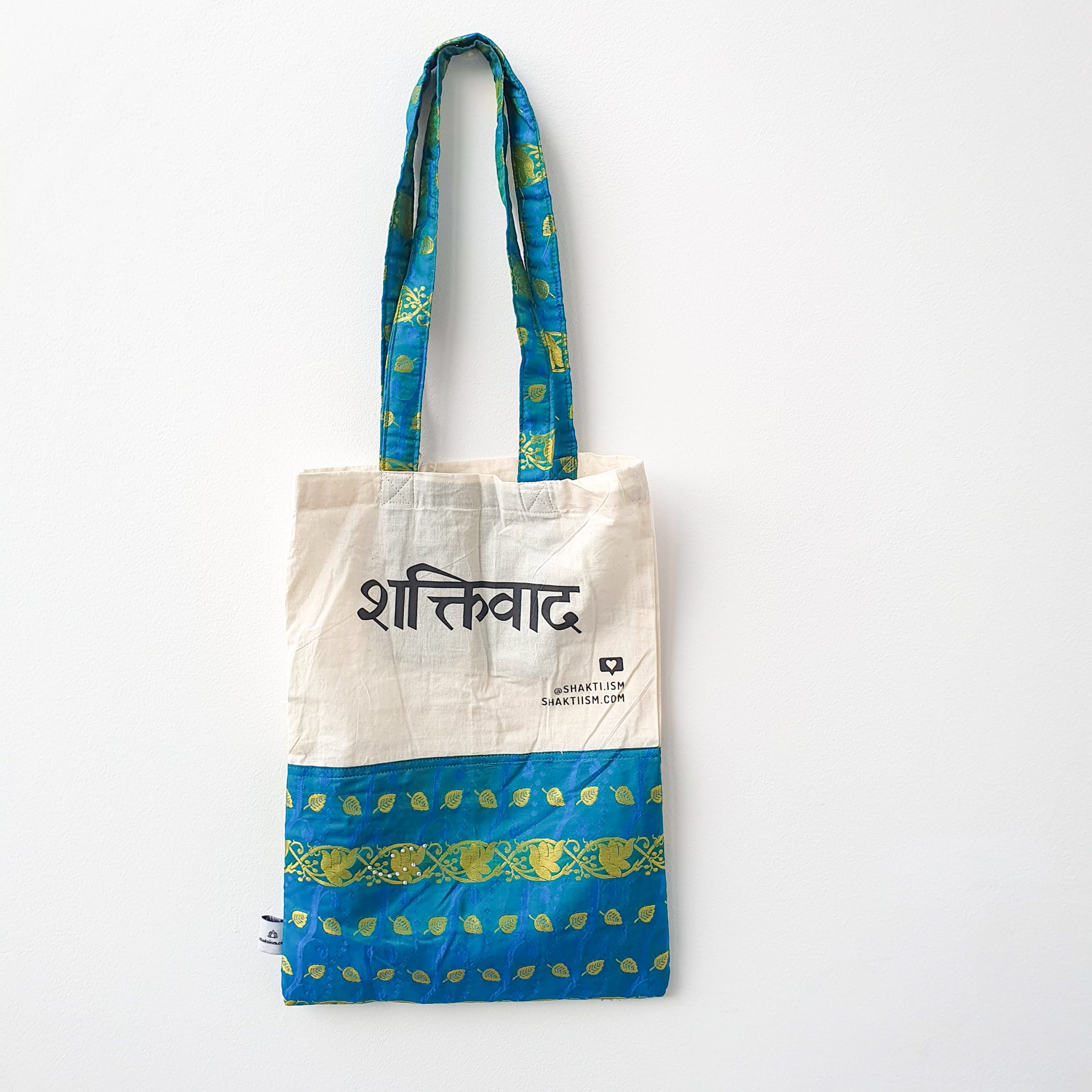 A vibrant Independence sari tote bag handcrafted from repurposed sari fabric, showcasing unique patterns and colors, with a message promoting women's economic independence.