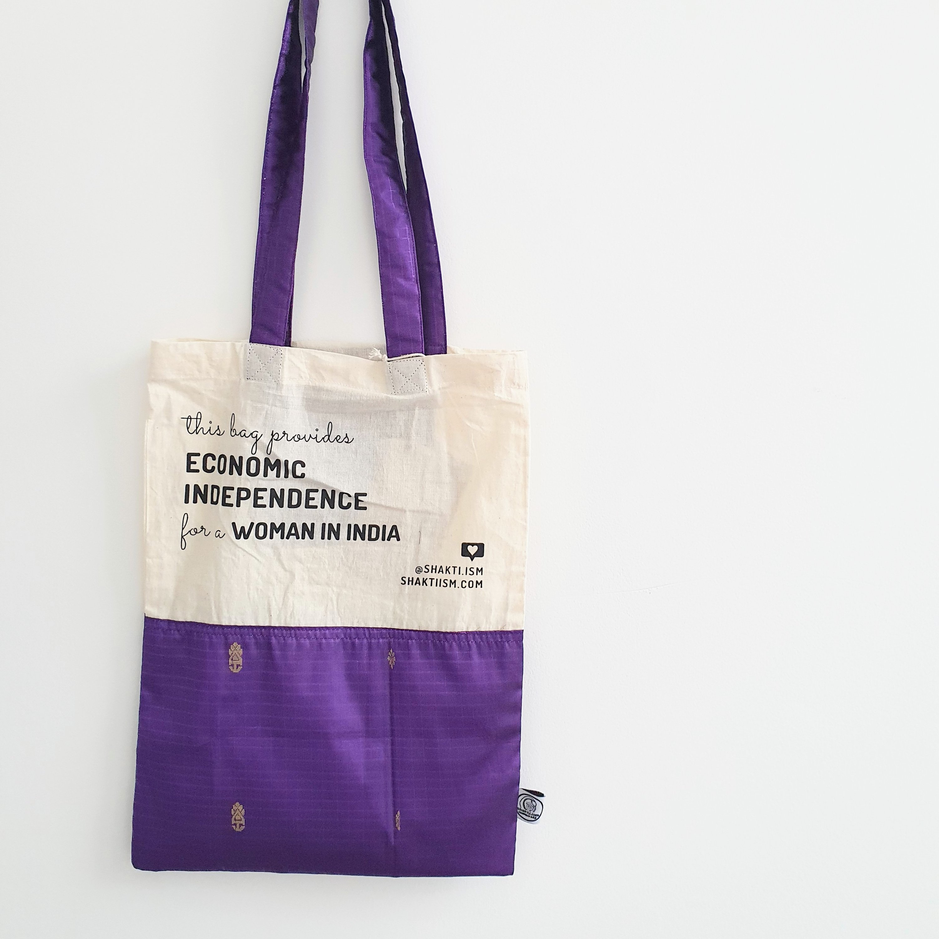 A vibrant Independence sari tote bag handcrafted from repurposed sari fabric, showcasing unique patterns and colors, with a message promoting women's economic independence.