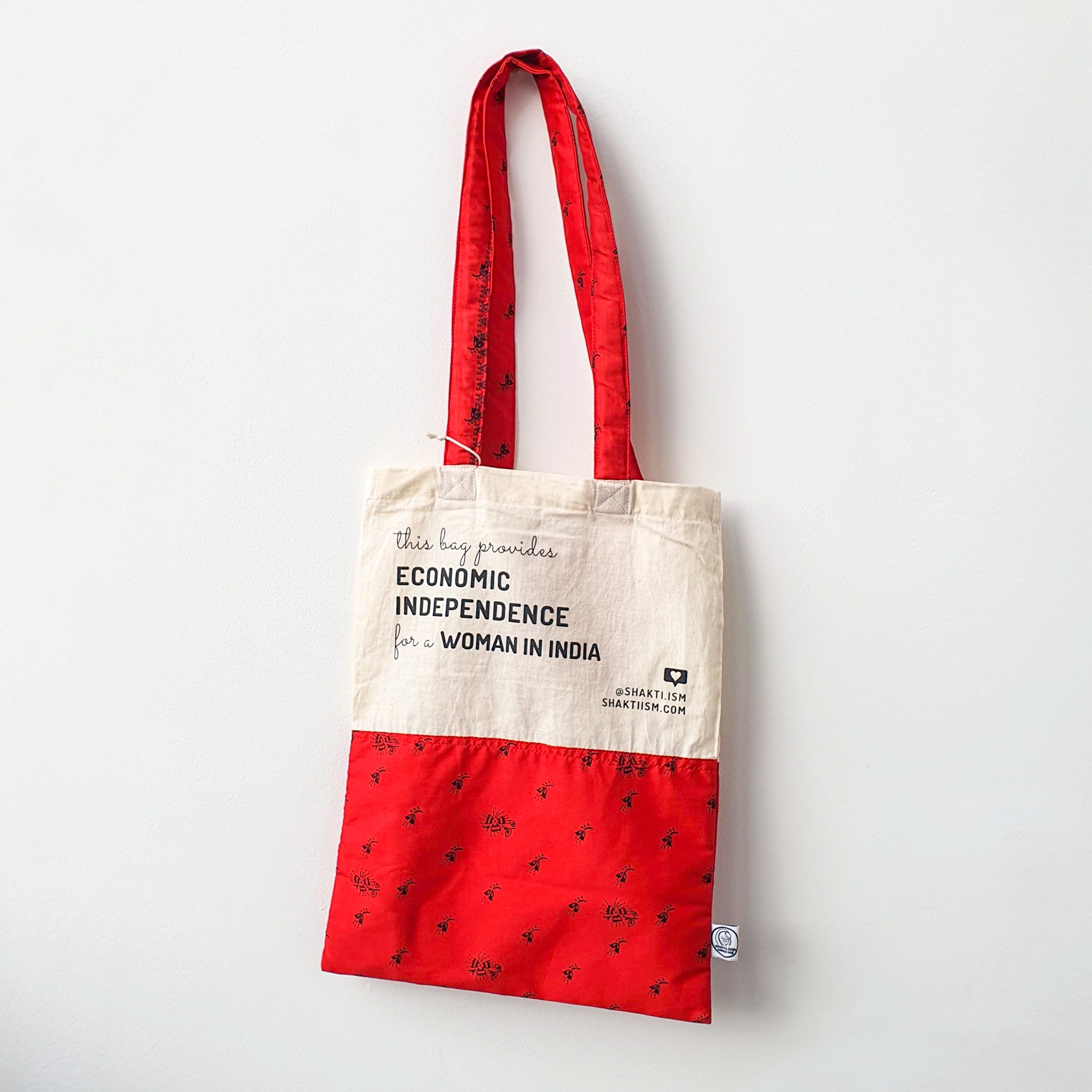 A vibrant Independence sari tote bag handcrafted from repurposed sari fabric, showcasing unique patterns and colors, with a message promoting women's economic independence.