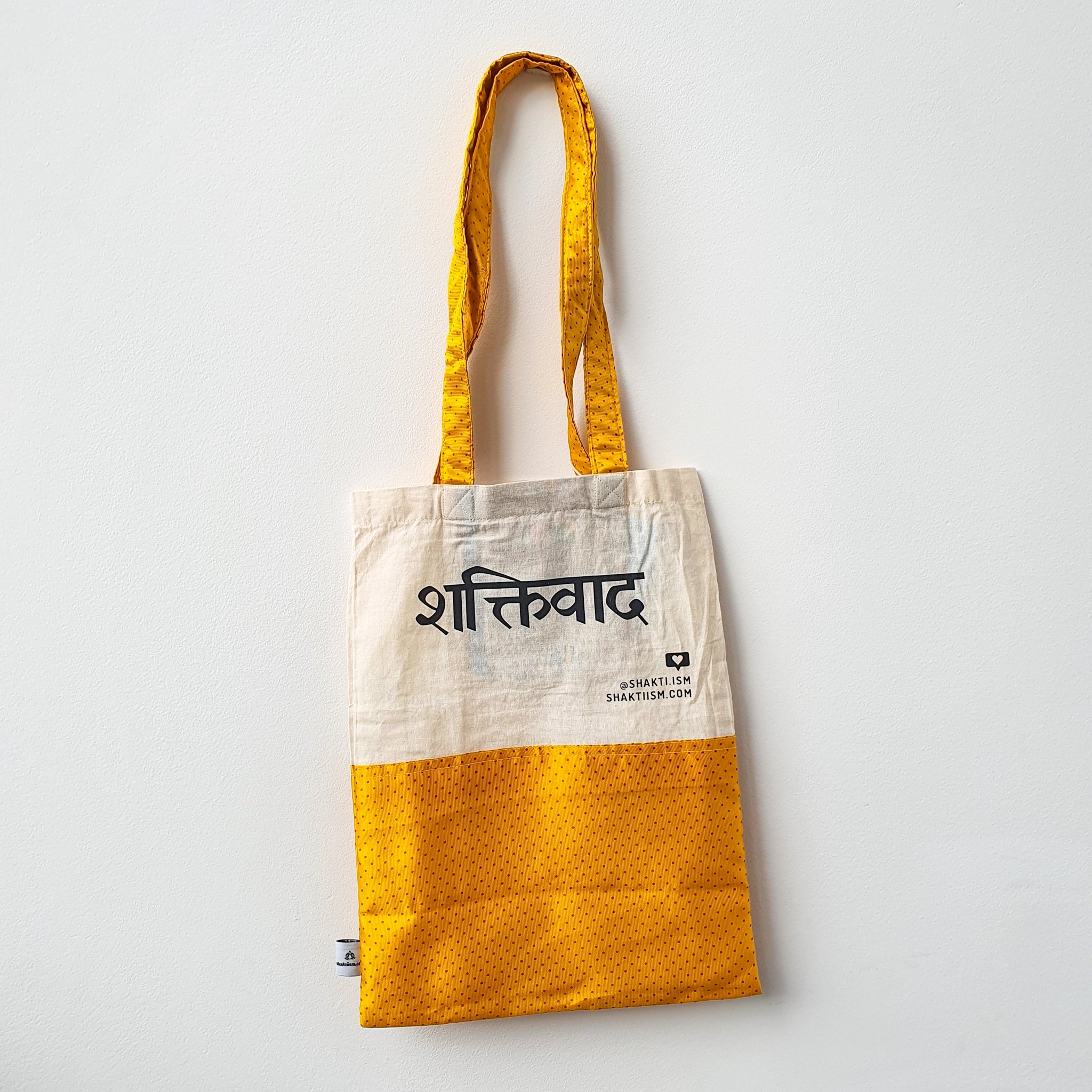 A vibrant Independence sari tote bag handcrafted from repurposed sari fabric, showcasing unique patterns and colors, with a message promoting women's economic independence.