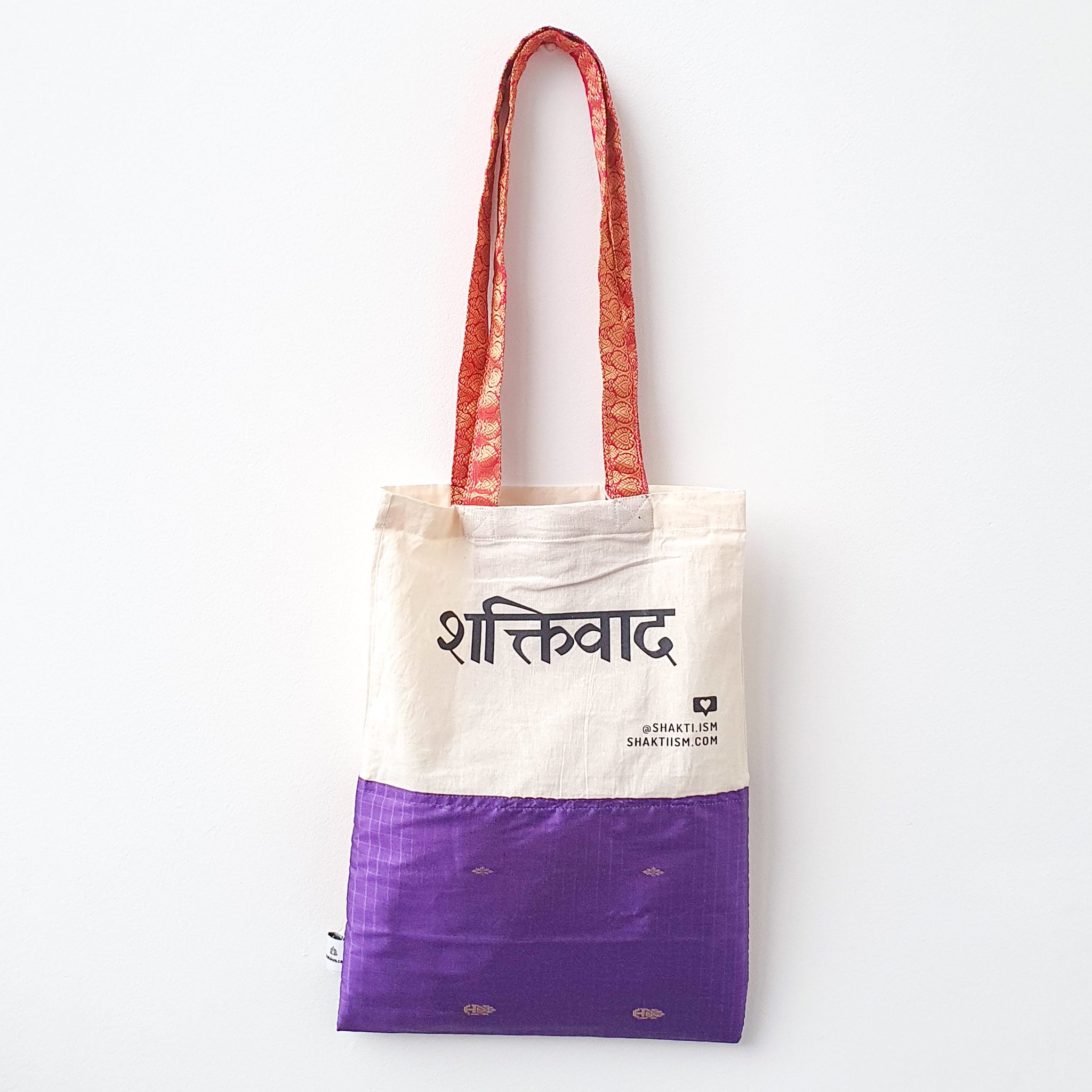 A vibrant Independence sari tote bag handcrafted from repurposed sari fabric, showcasing unique patterns and colors, with a message promoting women's economic independence.