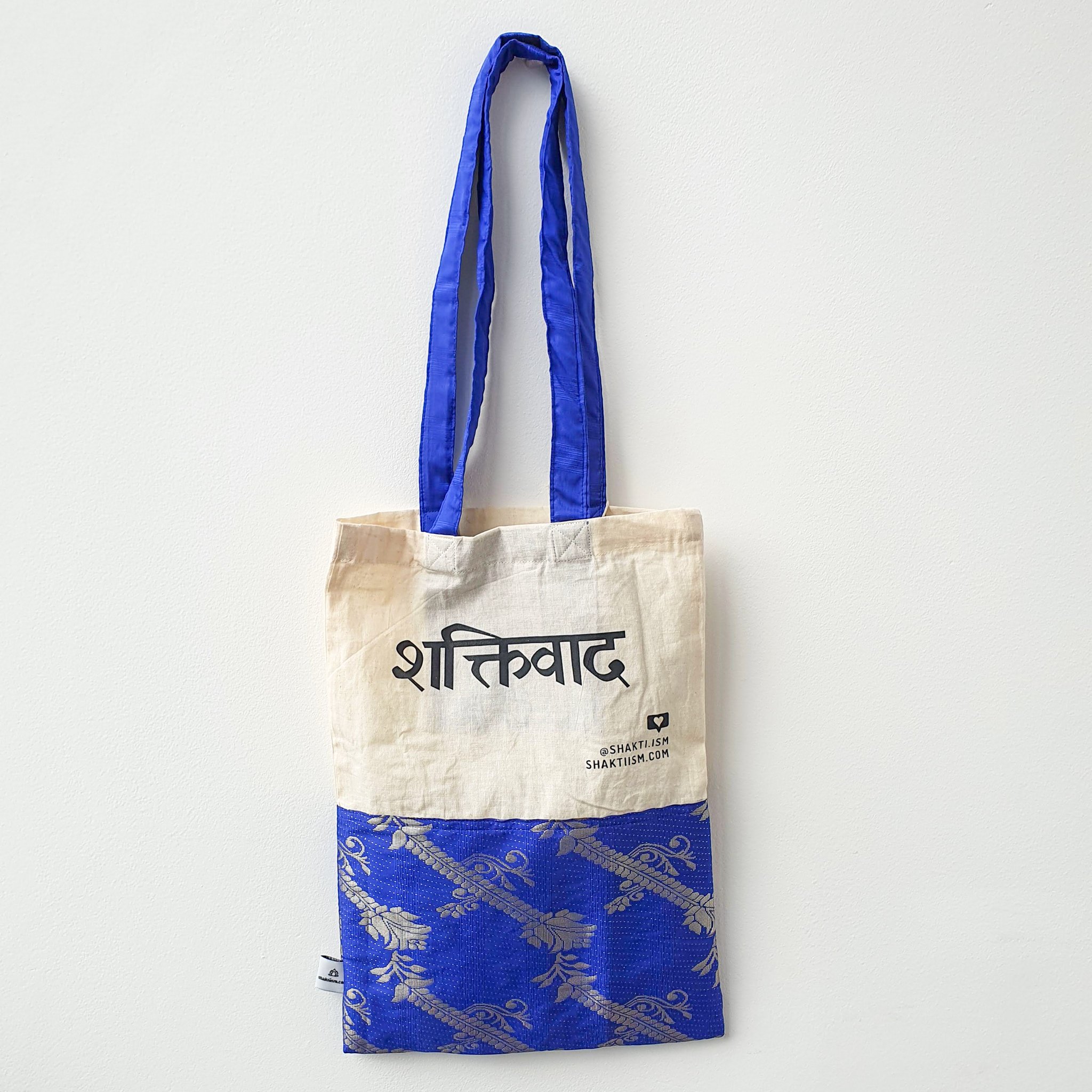 A vibrant Independence sari tote bag handcrafted from repurposed sari fabric, showcasing unique patterns and colors, with a message promoting women's economic independence.