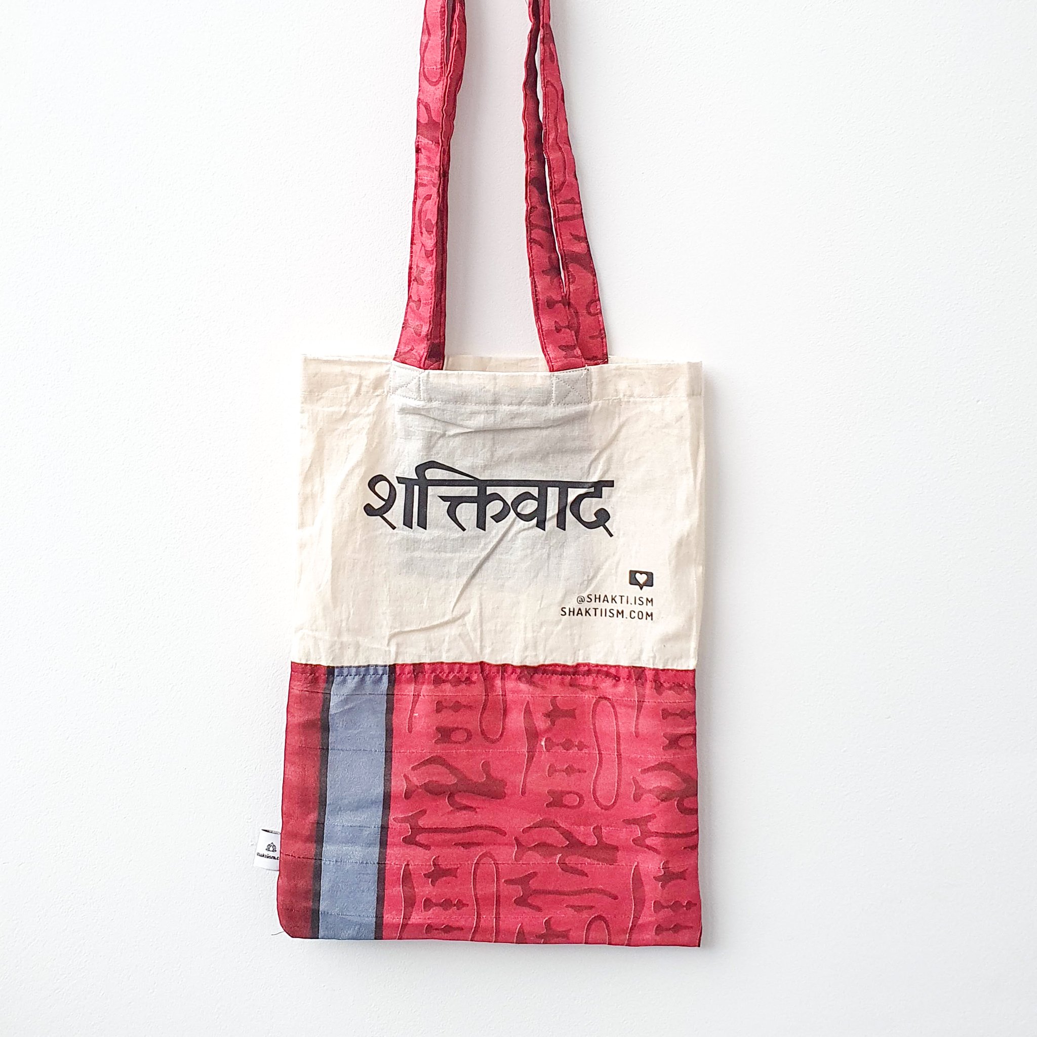 A vibrant Independence sari tote bag handcrafted from repurposed sari fabric, showcasing unique patterns and colors, with a message promoting women's economic independence.