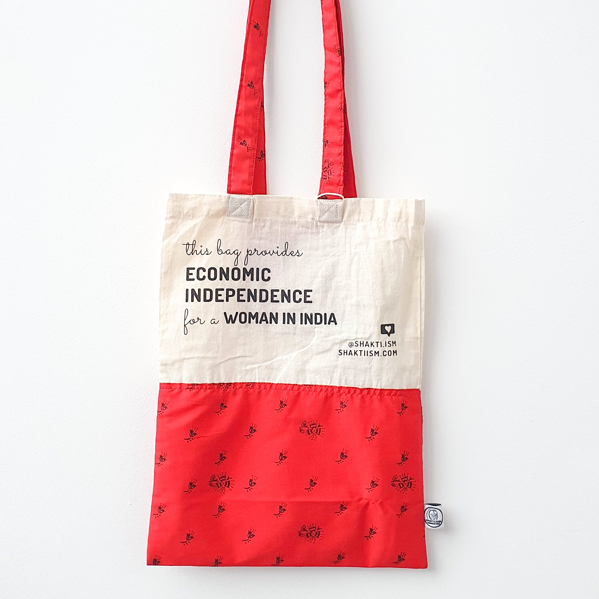 A vibrant Independence sari tote bag handcrafted from repurposed sari fabric, showcasing unique patterns and colors, with a message promoting women's economic independence.