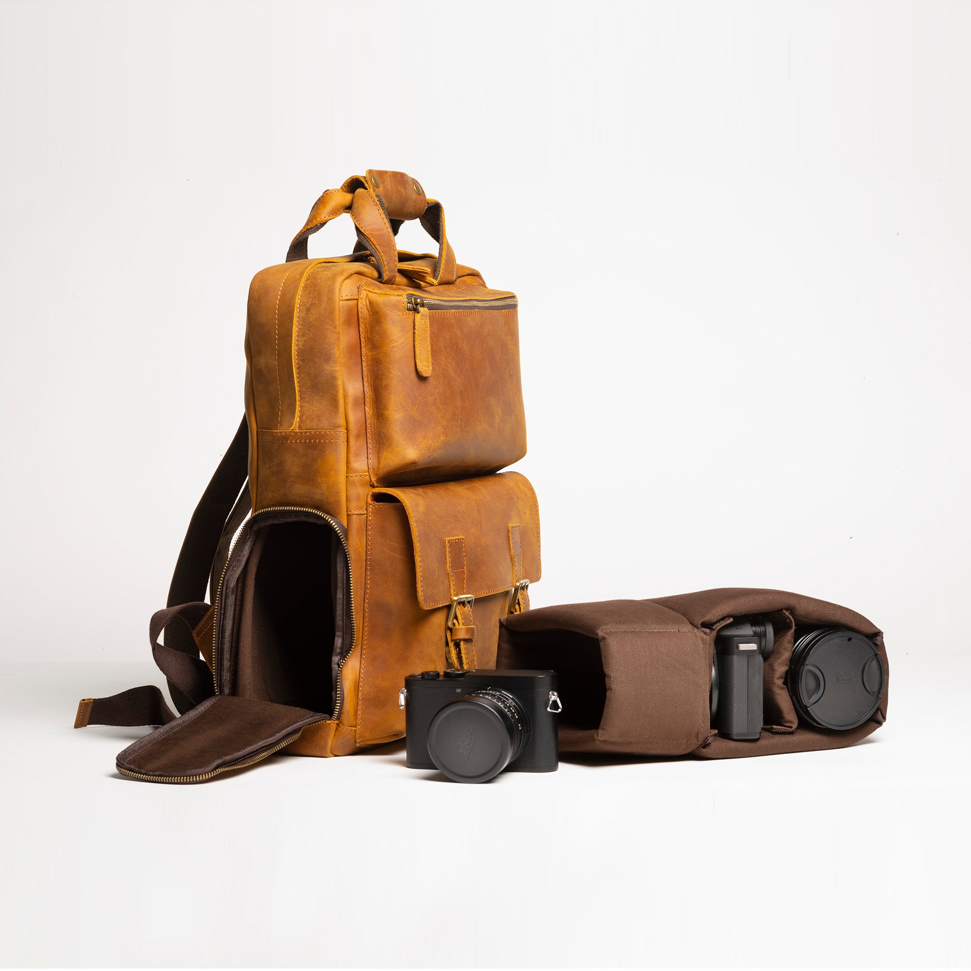 The MANN Bag, a large capacity leather camera backpack, showcasing its sleek design, padded compartments, and adjustable straps.