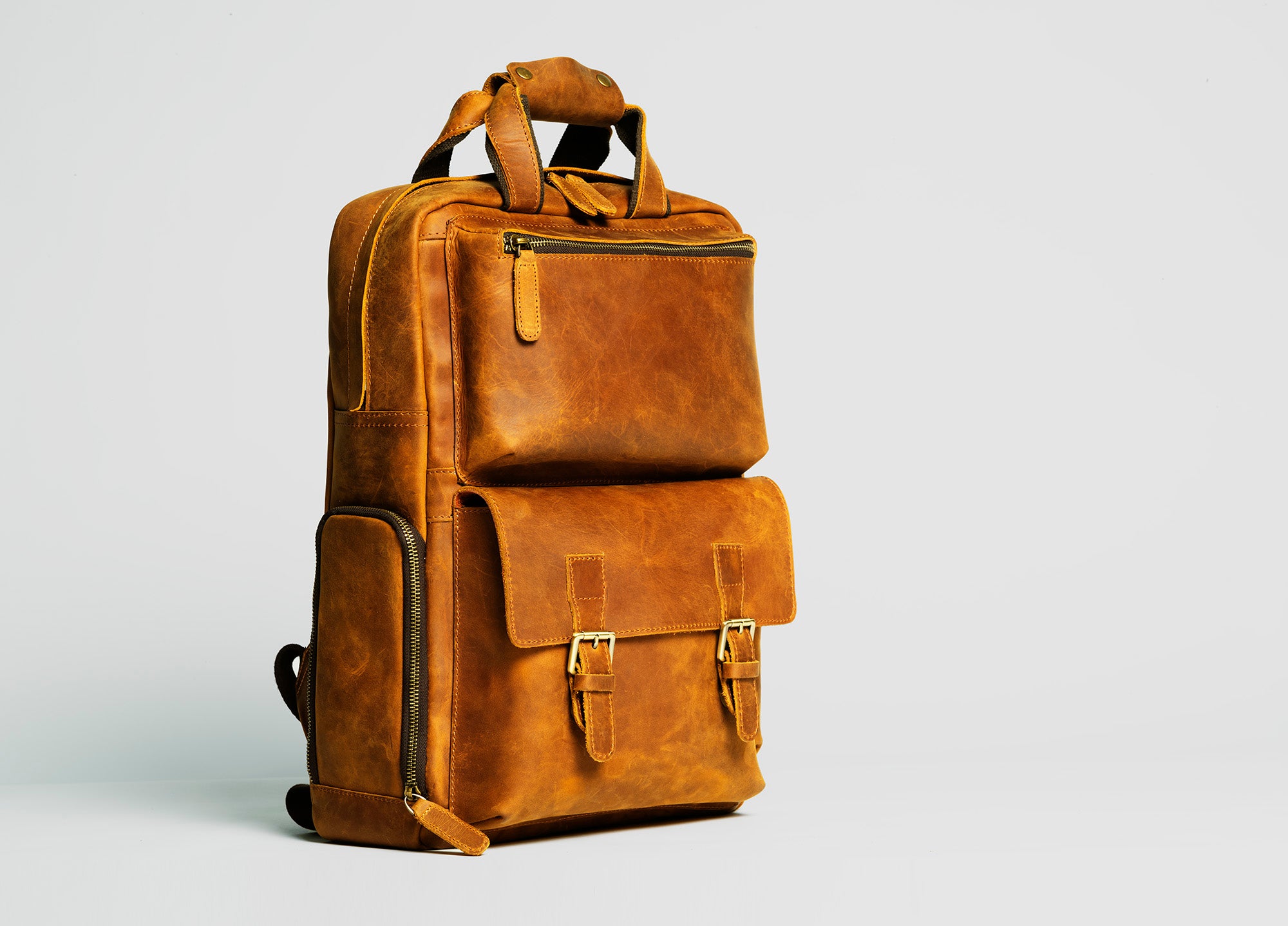 The MANN Bag, a large capacity leather camera backpack, showcasing its sleek design, padded compartments, and adjustable straps.