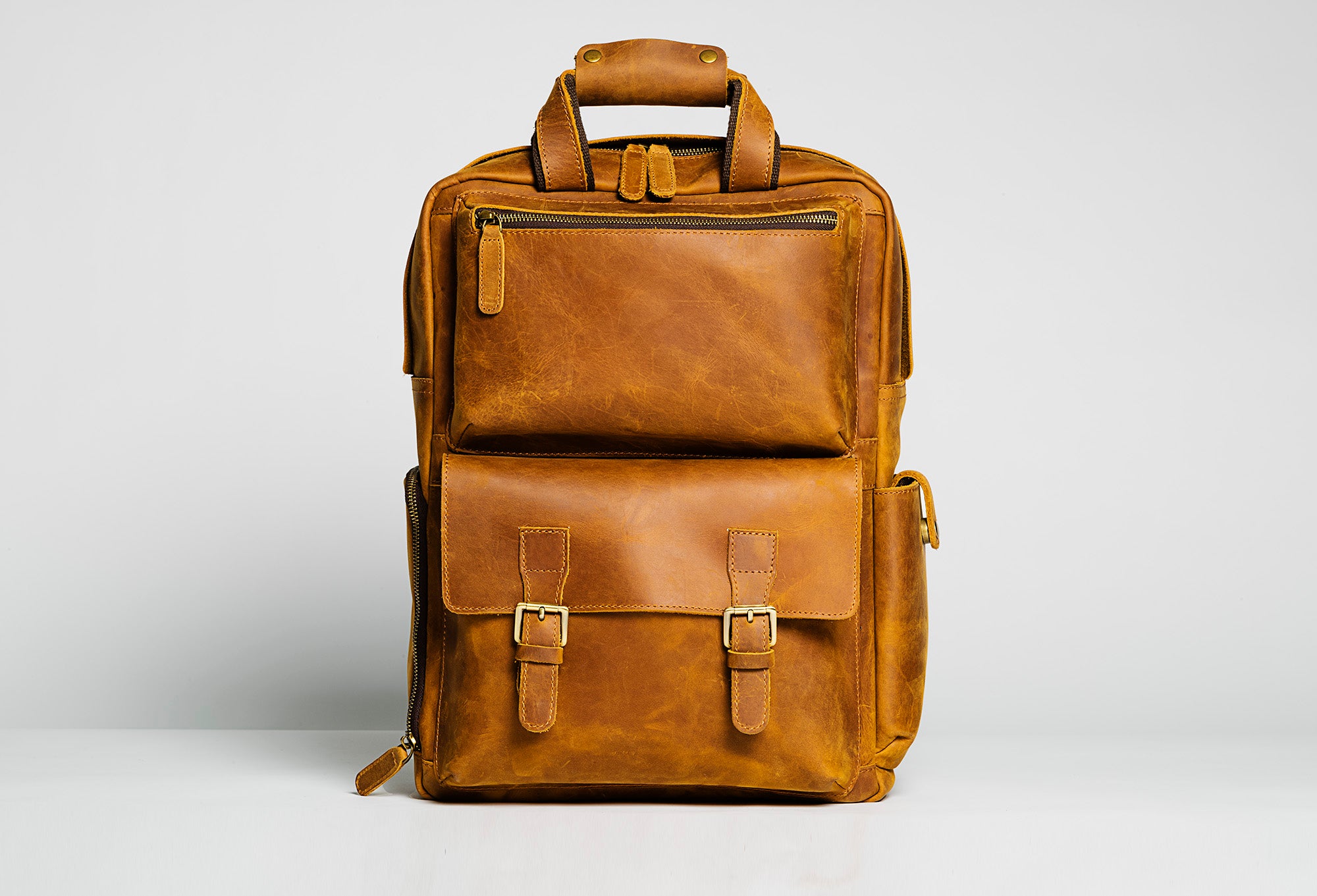 The MANN Bag, a large capacity leather camera backpack, showcasing its sleek design, padded compartments, and adjustable straps.