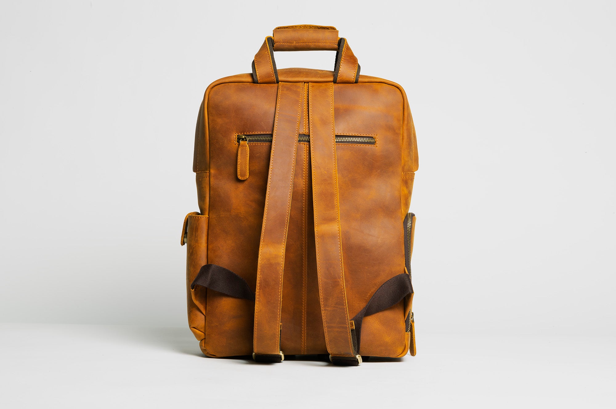 The MANN Bag, a large capacity leather camera backpack, showcasing its sleek design, padded compartments, and adjustable straps.