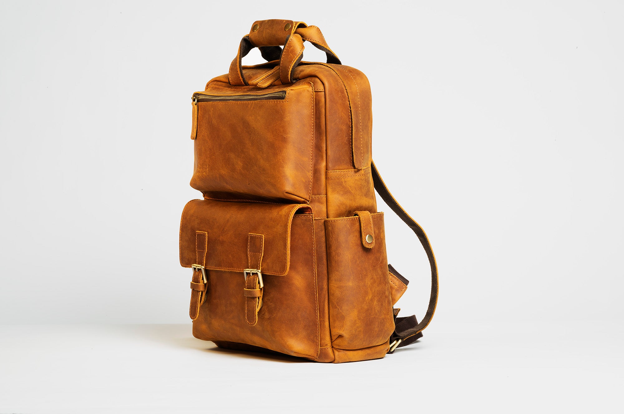 The MANN Bag, a large capacity leather camera backpack, showcasing its sleek design, padded compartments, and adjustable straps.