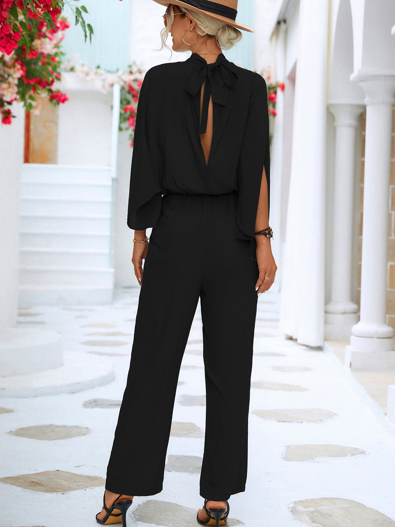 A stylish Tie Back Mock Neck Split Sleeve Jumpsuit displayed on a mannequin, featuring a mock neck and split sleeves in a solid color.