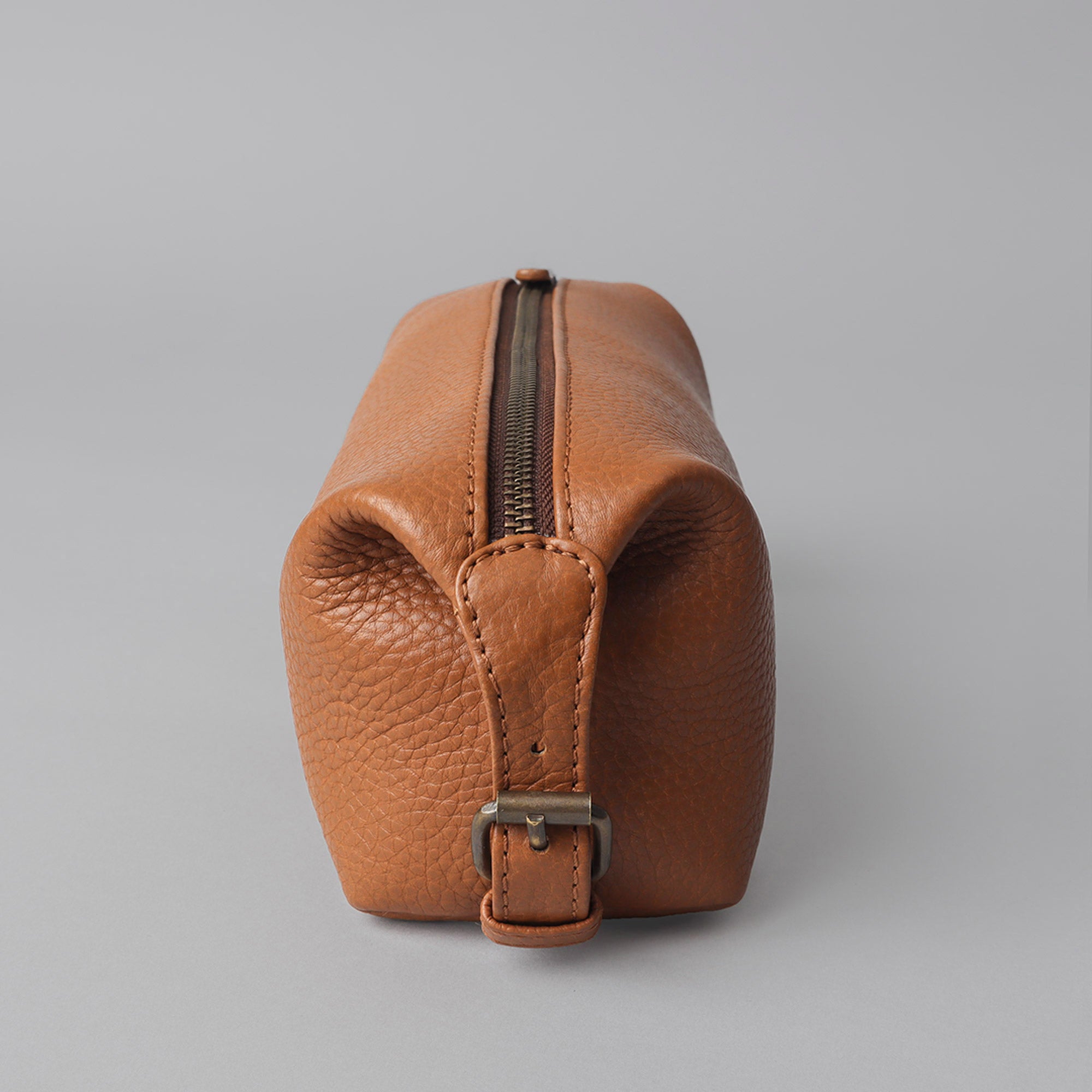 Tokyo Toilet Bag made of premium full grain leather, featuring a spacious interior, zipper pocket, and antique brass hardware.