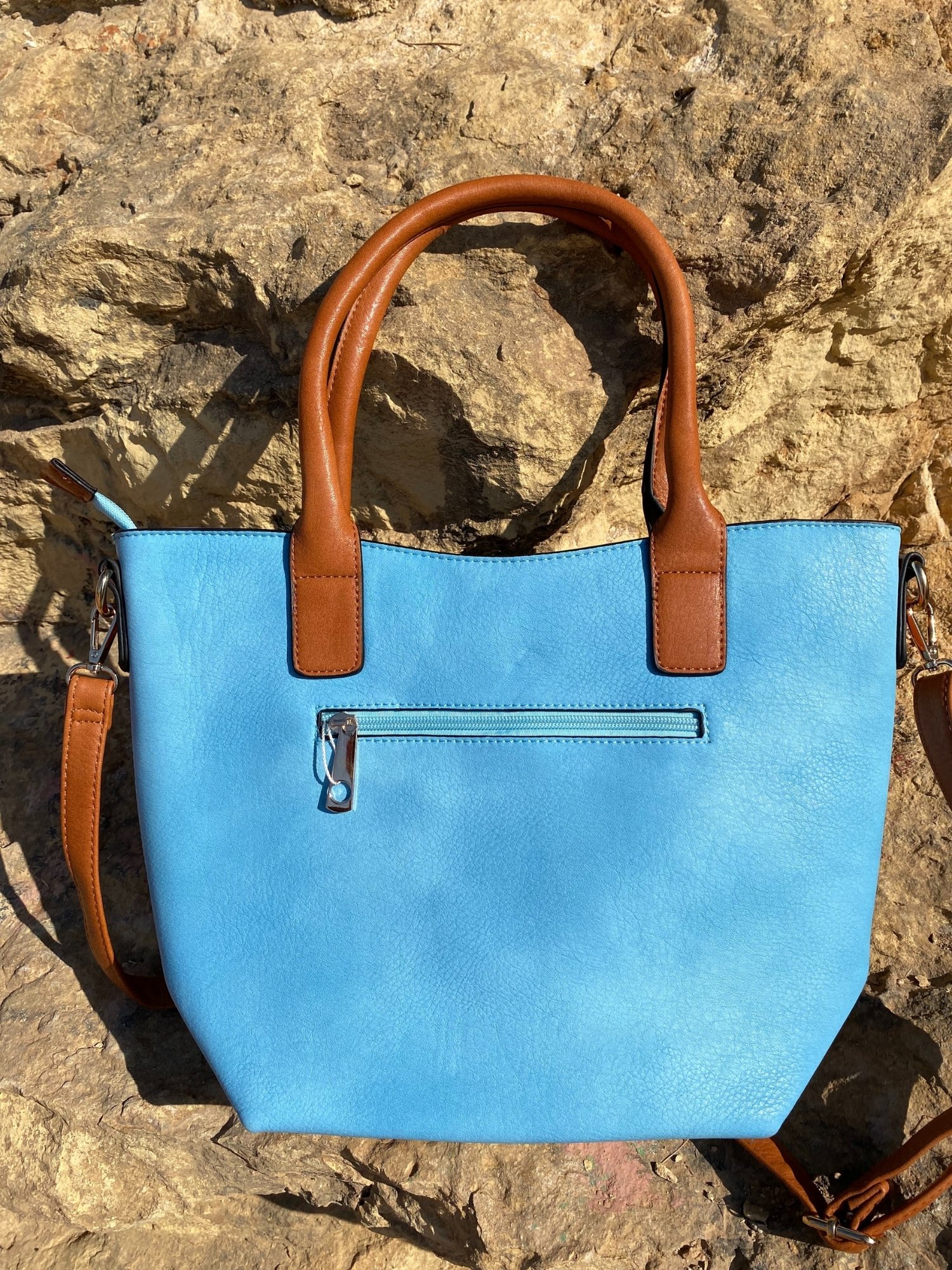 Light blue tote bag with zip closure, metallic details, and adjustable shoulder strap.