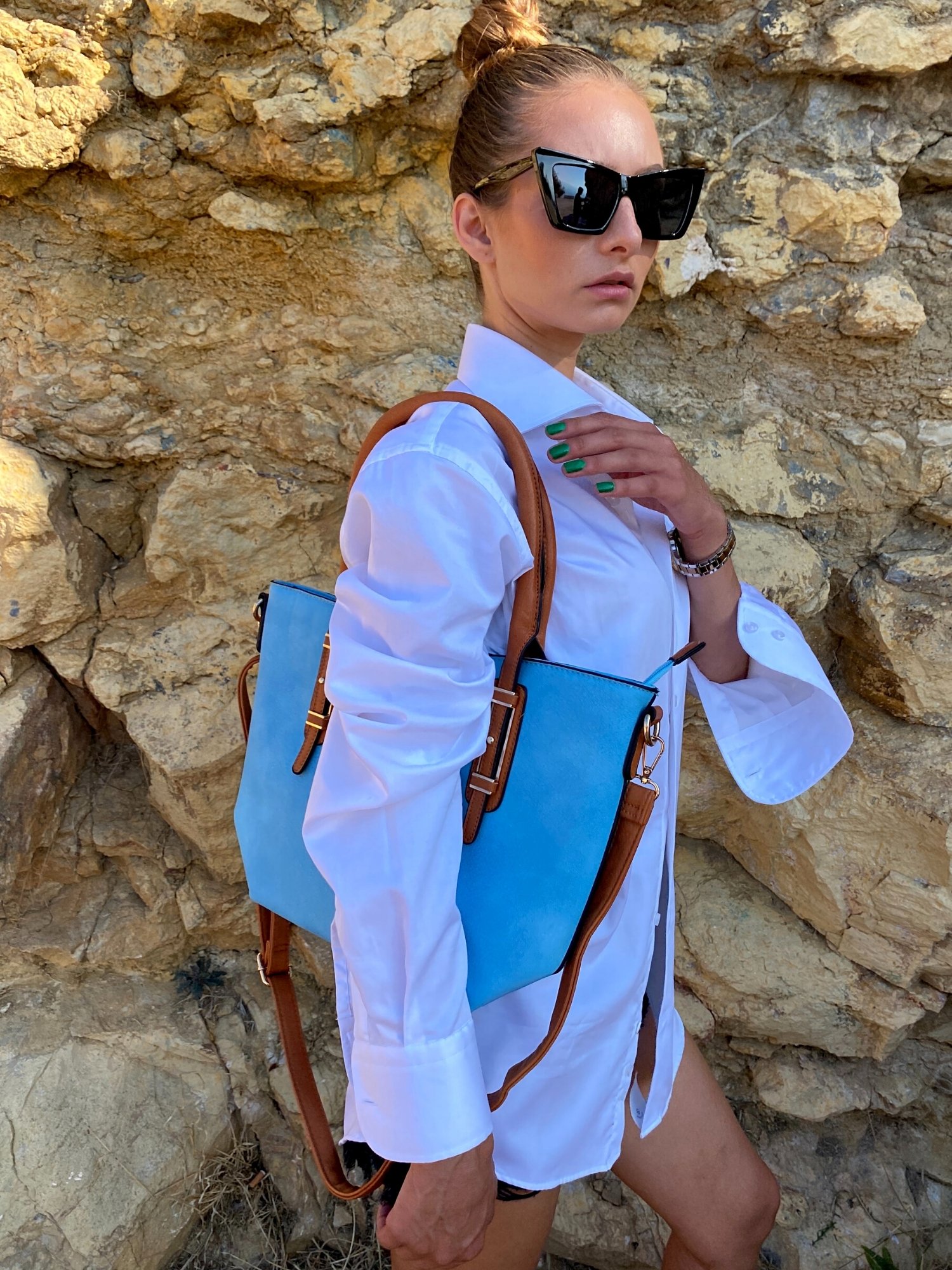 Light blue tote bag with zip closure, metallic details, and adjustable shoulder strap.