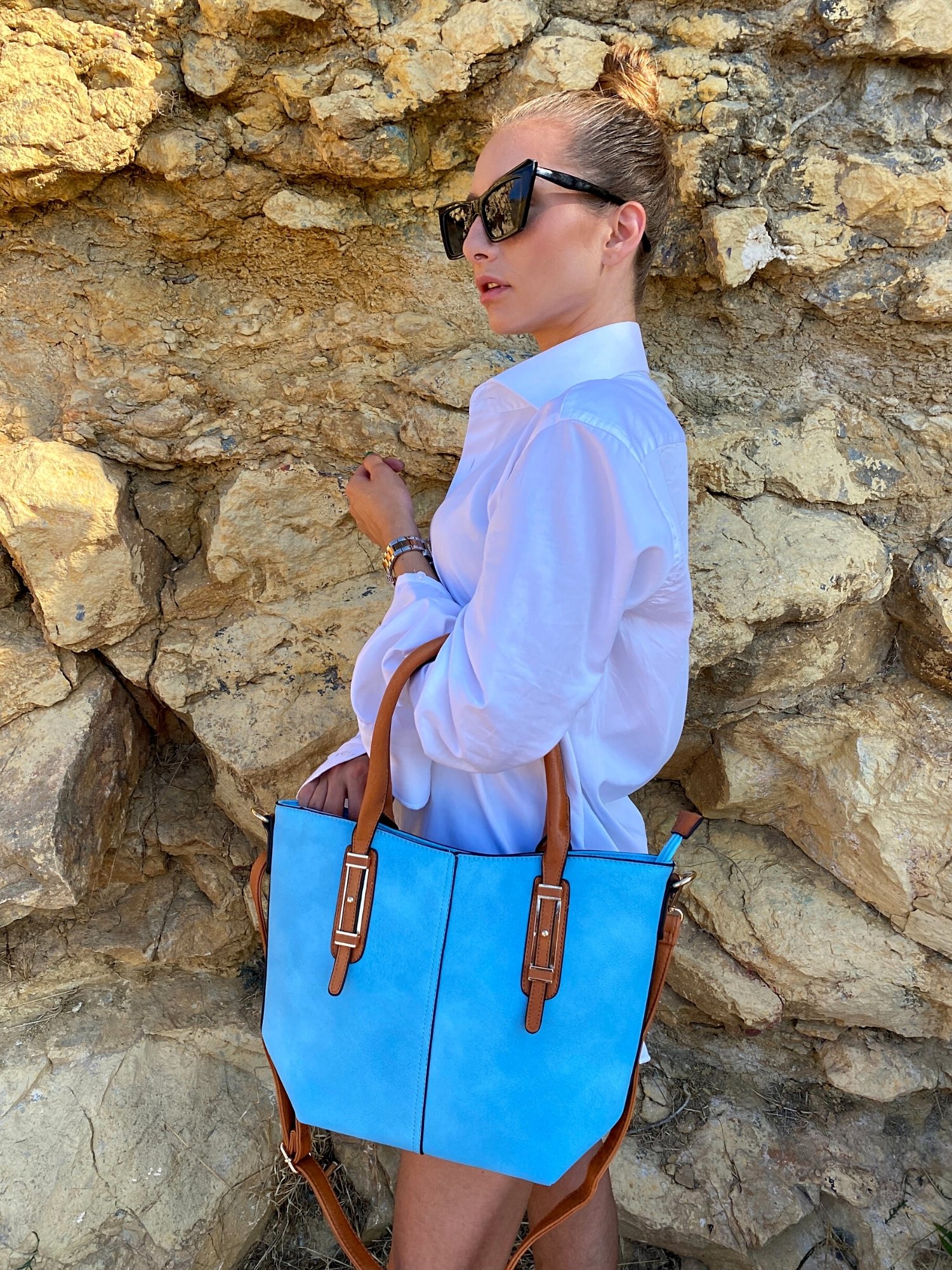 Light blue tote bag with zip closure, metallic details, and adjustable shoulder strap.